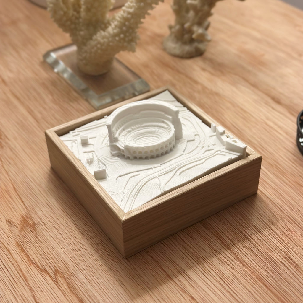 3D city map wall art with a white architectural model in a wooden frame on a wooden table