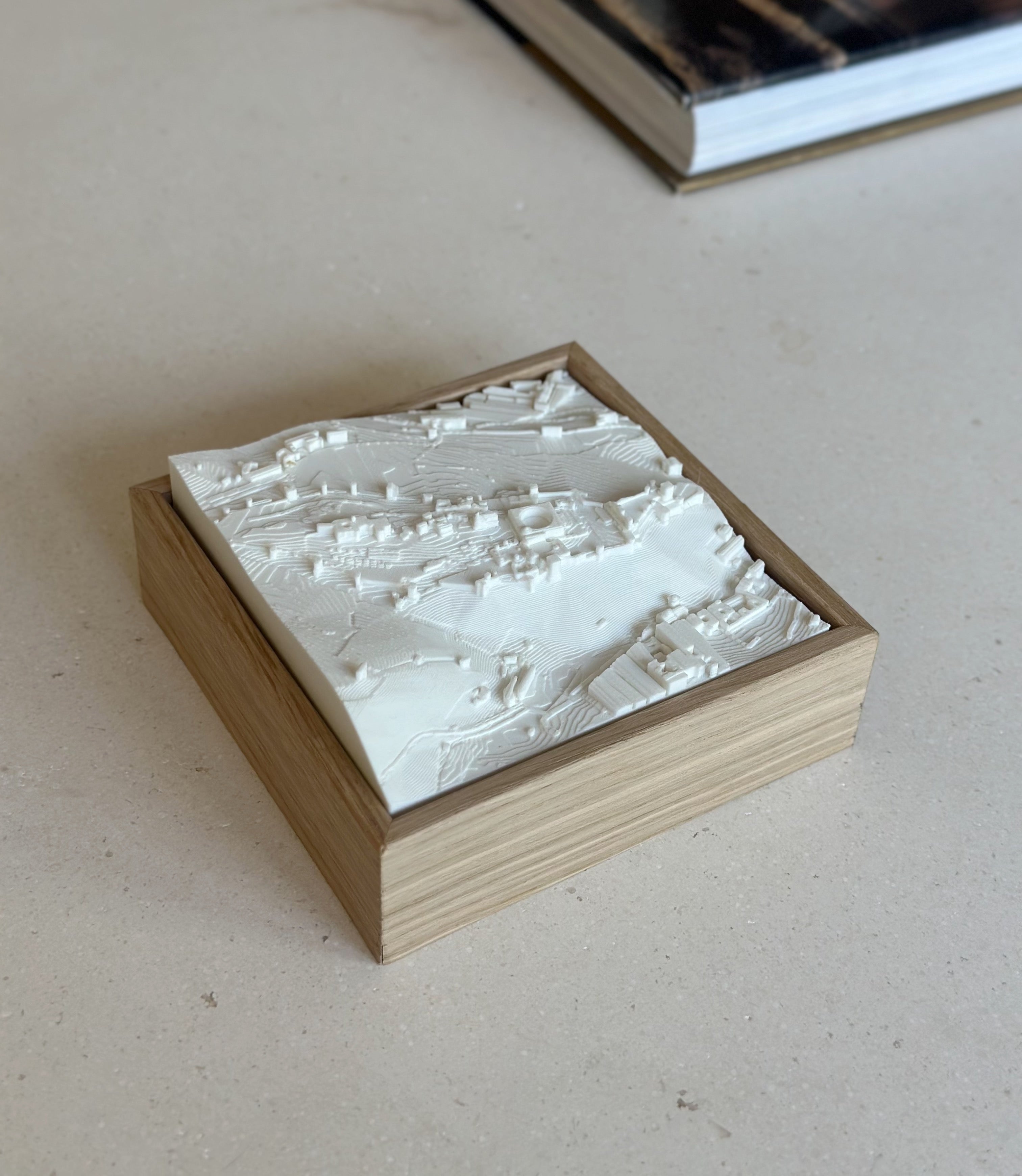 3D city map wall art in wood frame on beige surface, modern minimalist decor