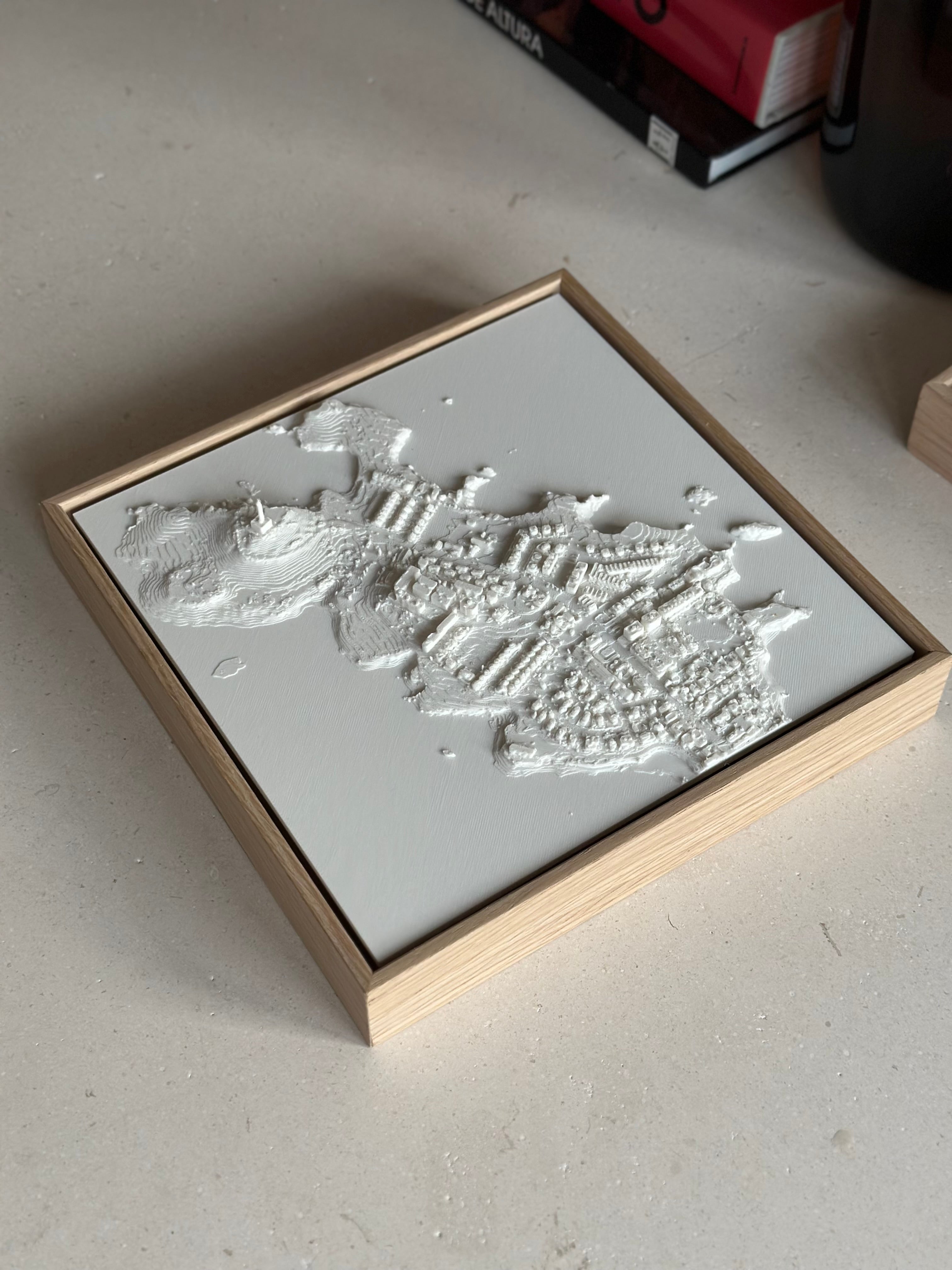 3D city map wall art in a wooden frame on a light surface, modern home decor