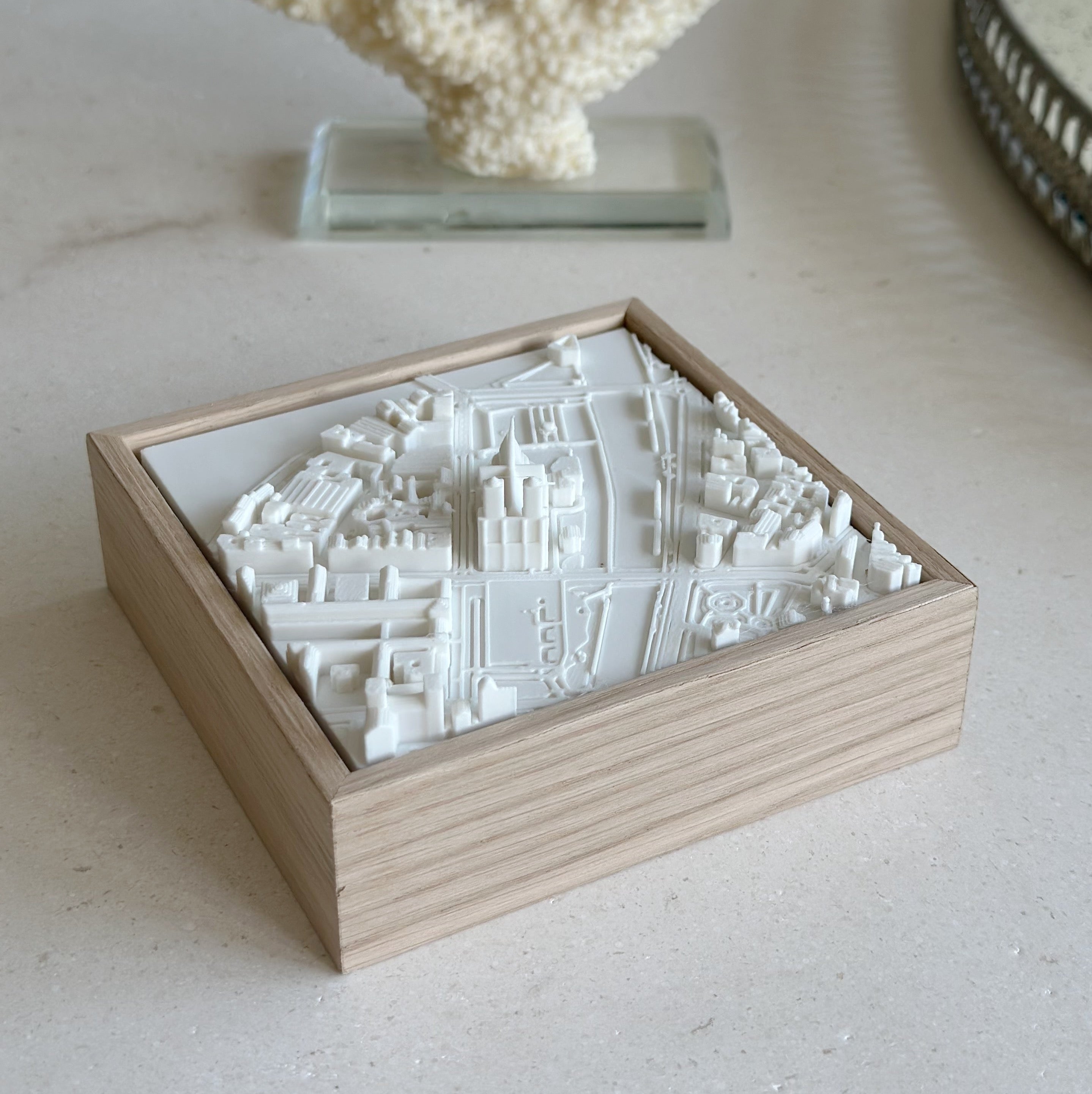 3D city map wall art in a wooden frame, minimalist decor on a light table
