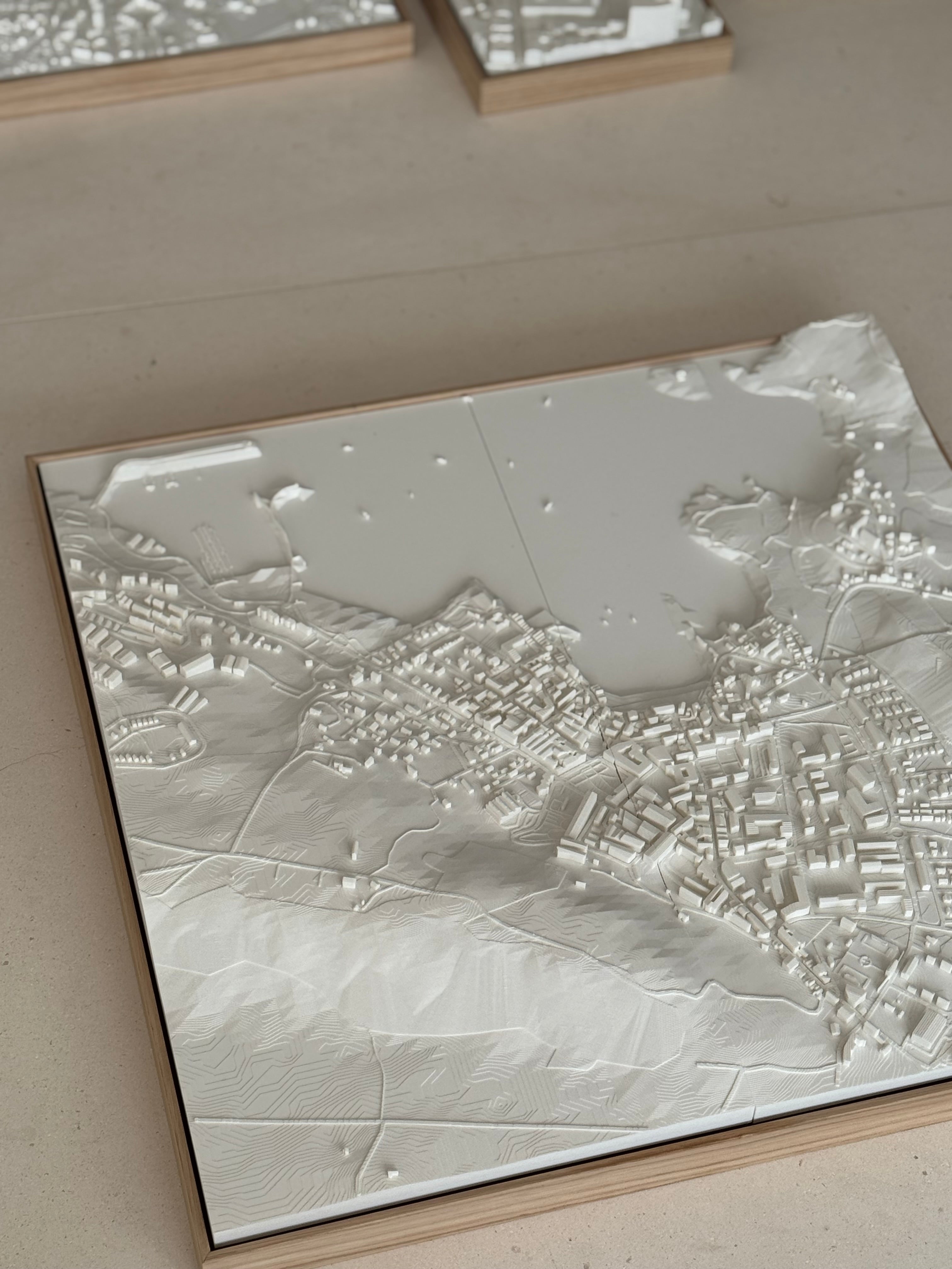 3D city map wall art with intricate building and landscape details in a wooden frame