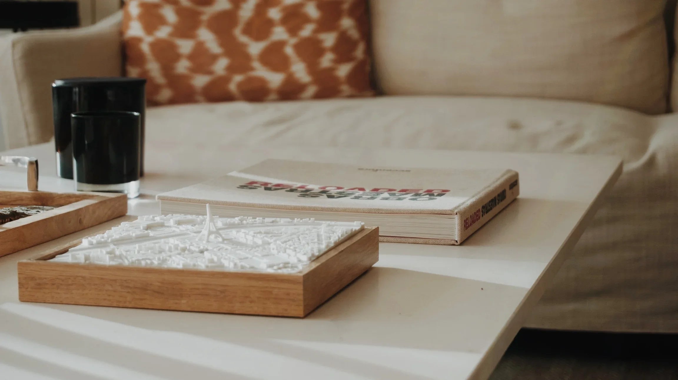 3D city map wall art on a coffee table with books and candles, modern home decor.