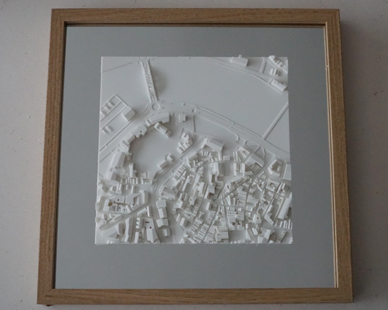 Framed 3D city map artwork with white raised buildings and streets, modern wall decor