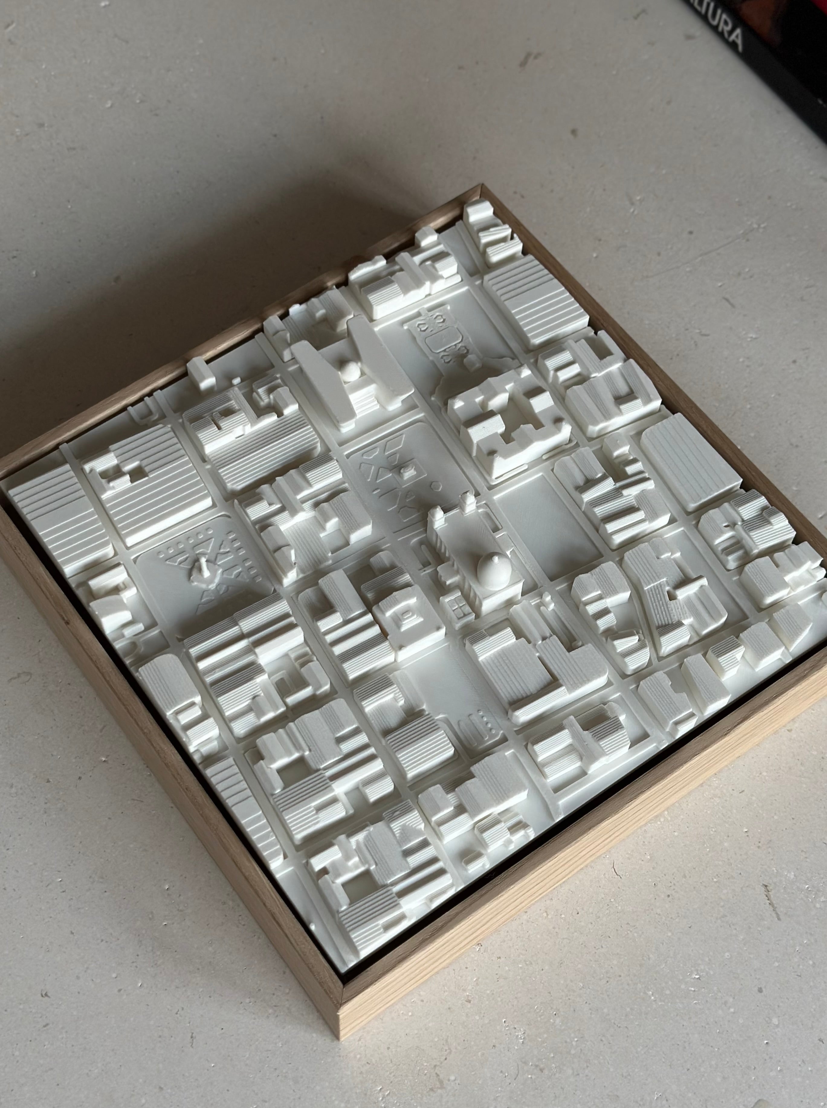 3D city map wall art in a wooden frame, featuring detailed miniature buildings.