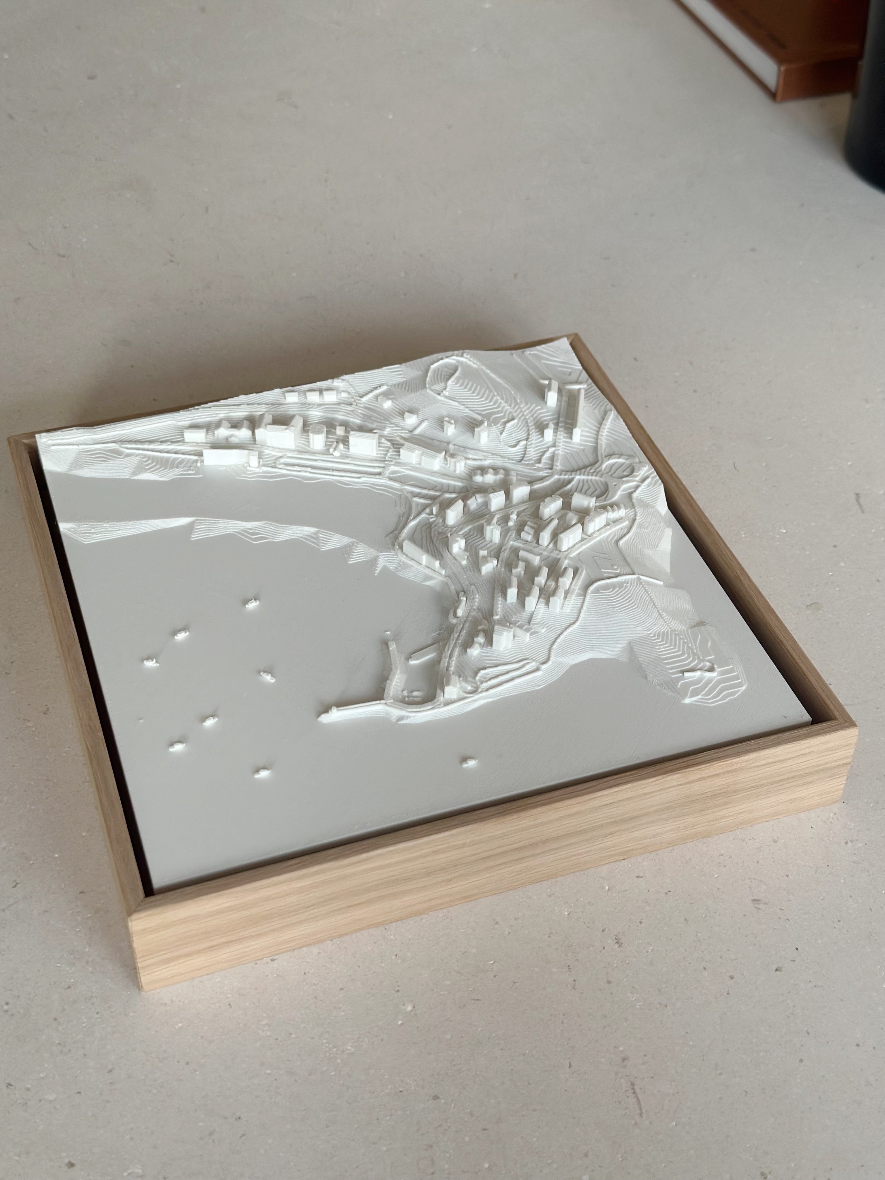 Framed 3D city map wall art in white relief on a light surface, modern home decor