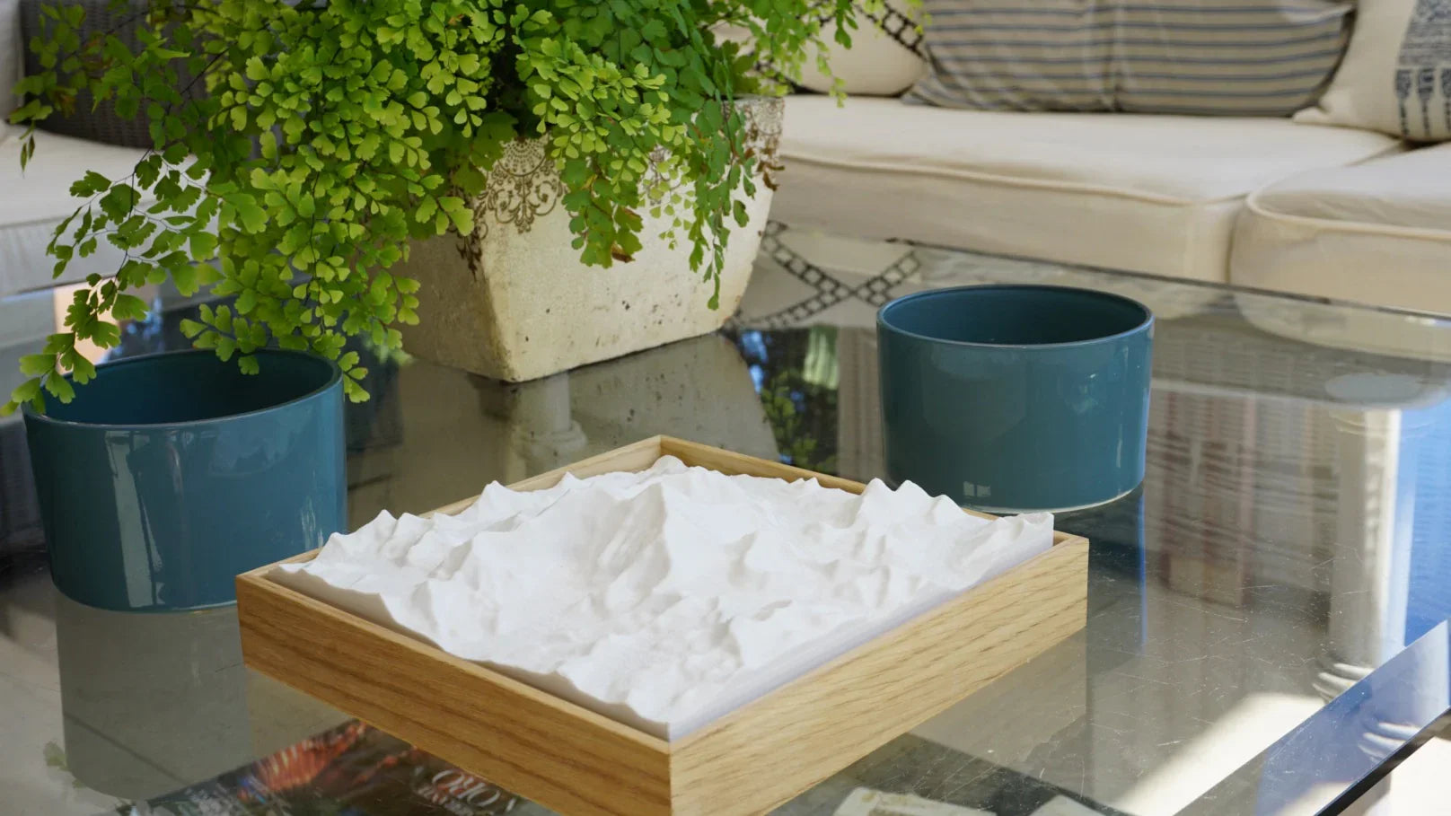 Modern living room with 3D city map decor in a wooden frame on a glass coffee table