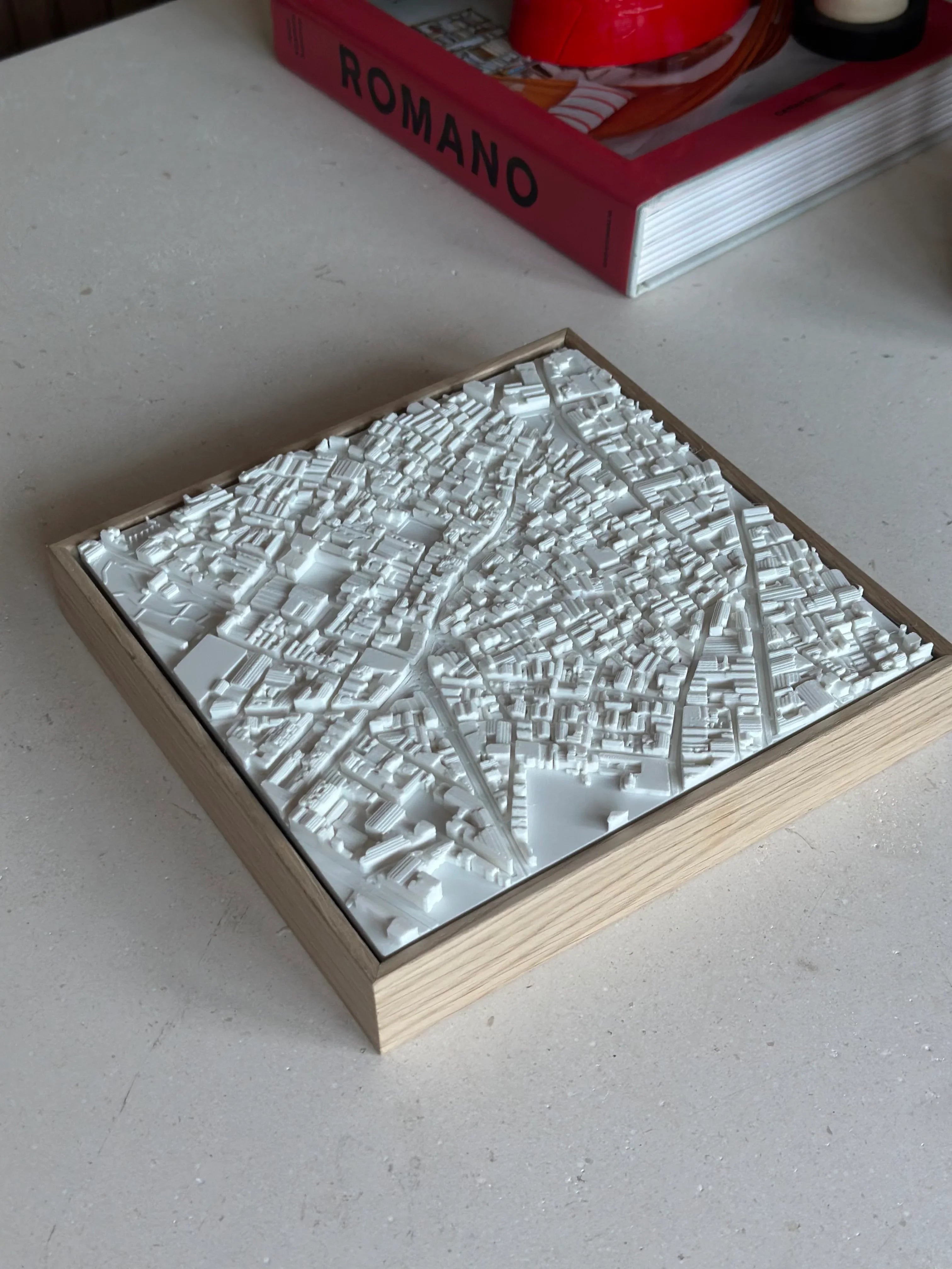 3D city map wall art in white with wooden frame on a table, modern urban decor