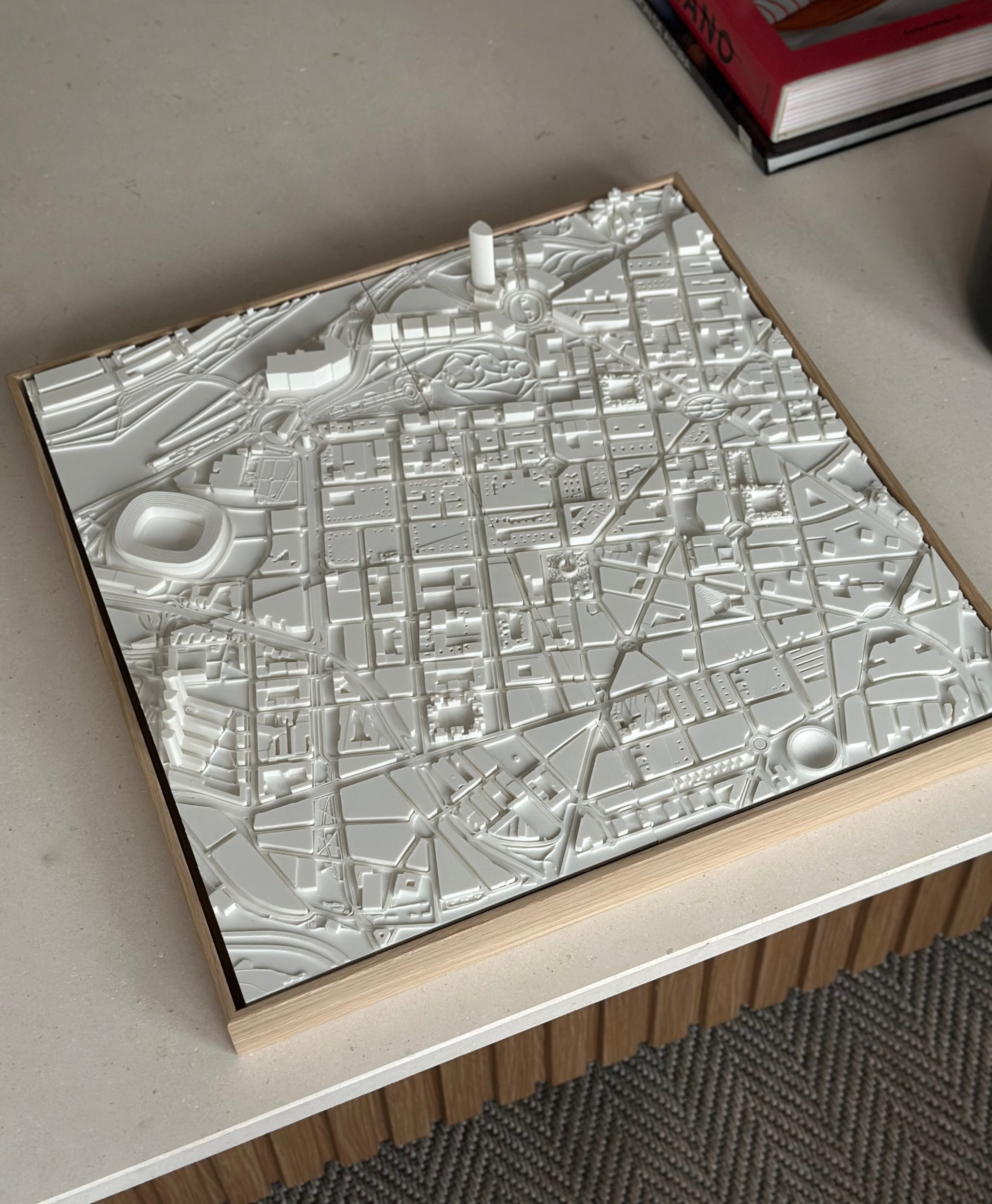 3D city map wall art in white, detailed urban streets and buildings, decorative frame on table