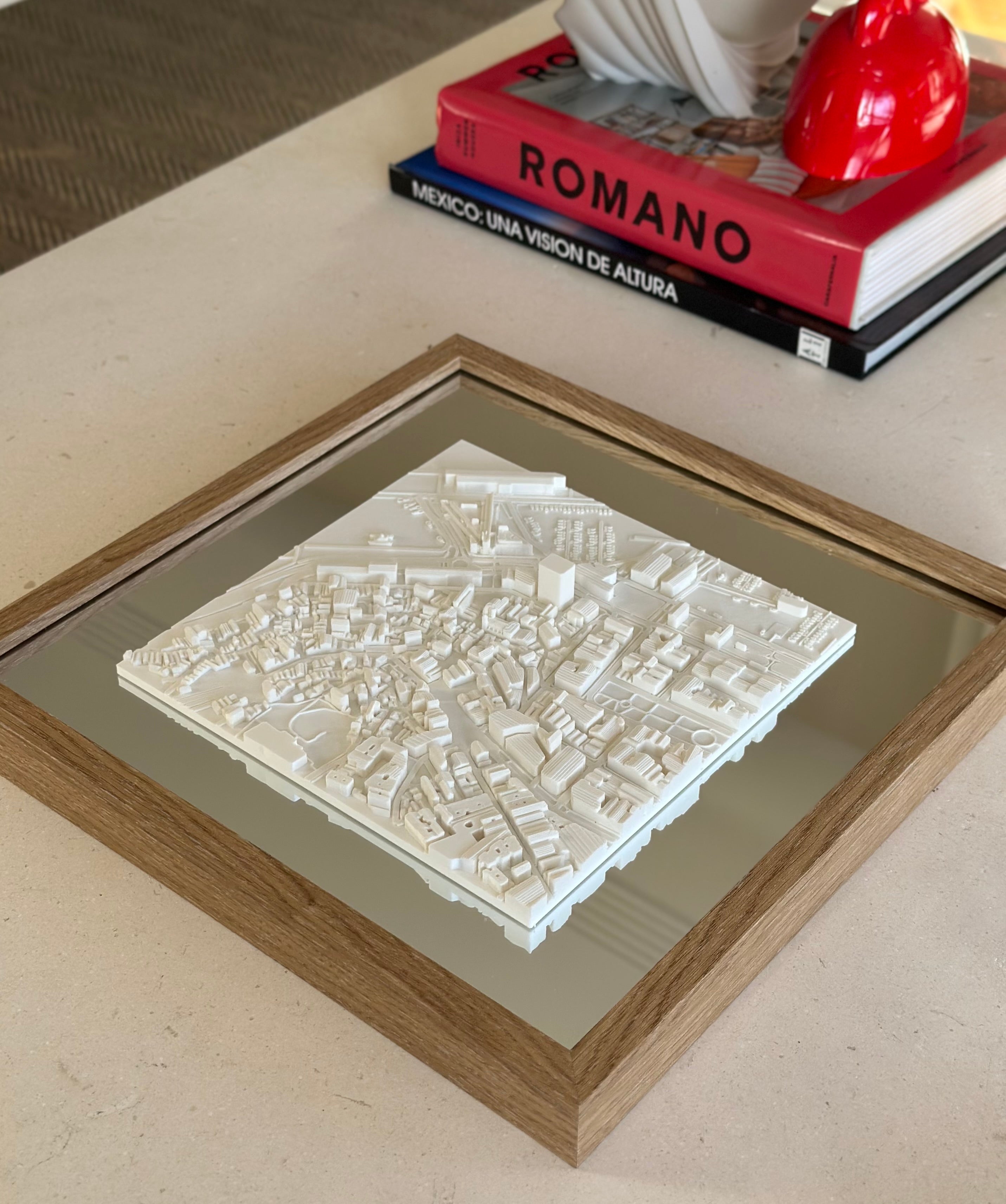 3D city map wall art in a wooden frame on a modern coffee table with books and decor