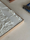 3D city map wall art in a wooden frame on a table, decorative urban landscape