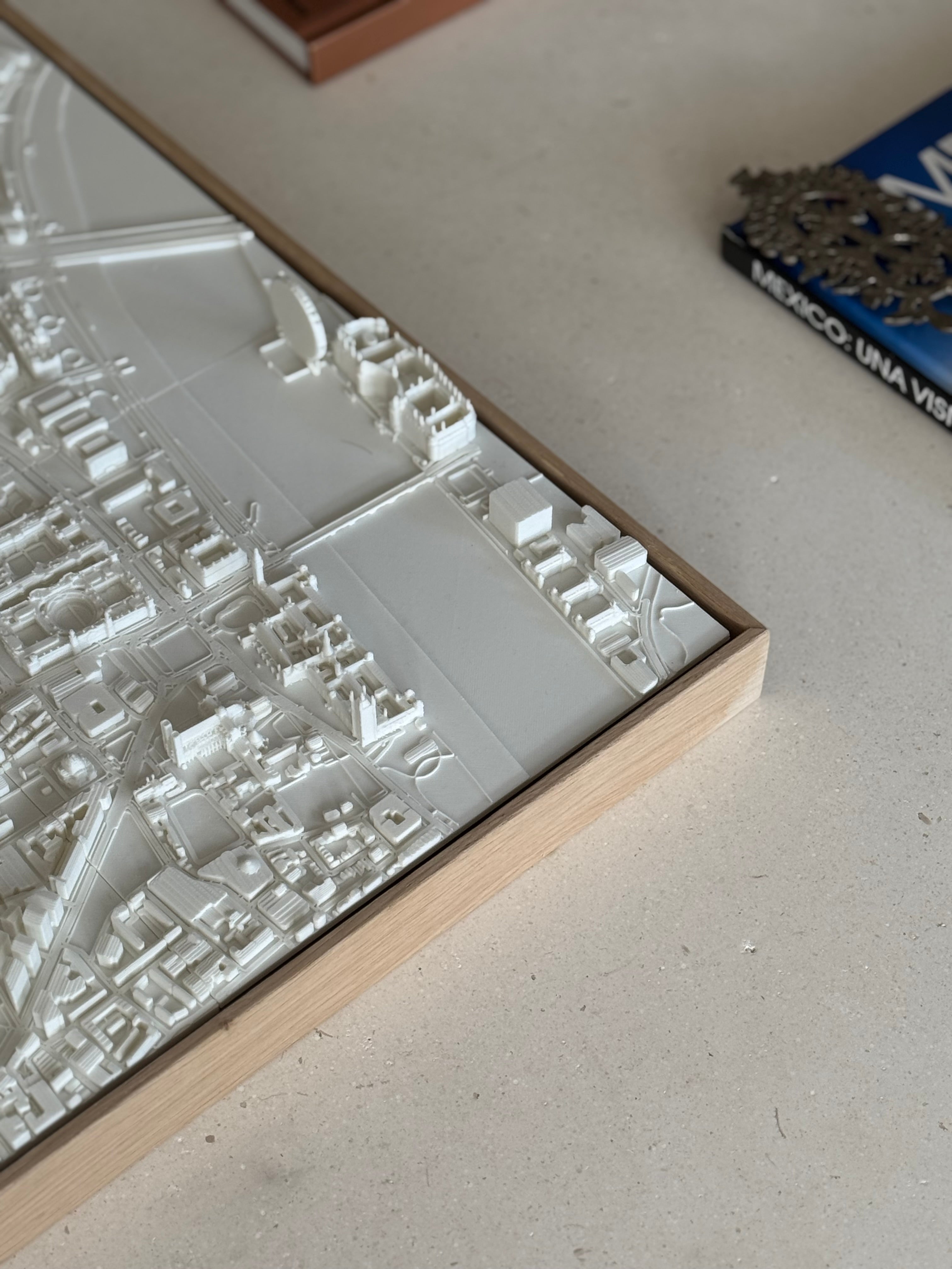 3D city map wall art in a wooden frame on a table, decorative urban landscape