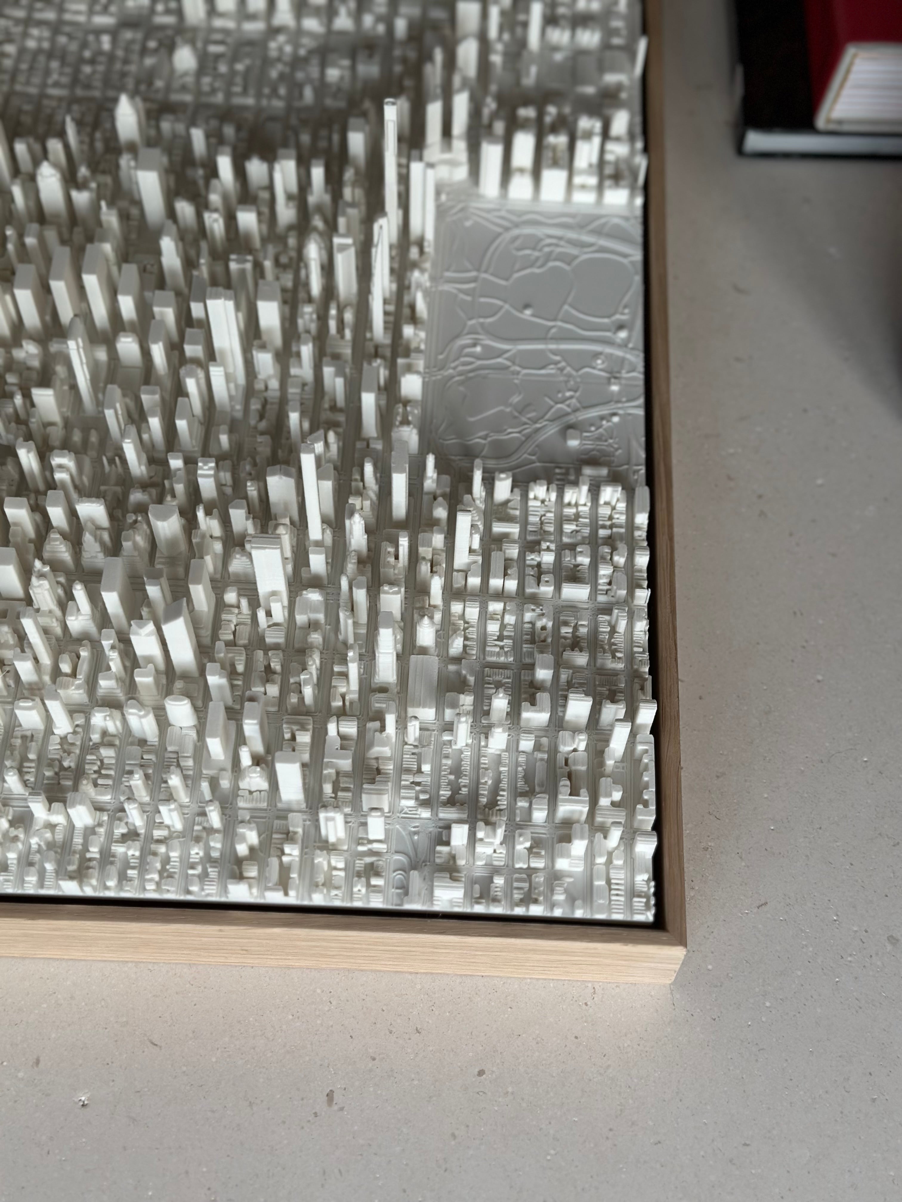 3D printed city map artwork with raised white buildings in a wooden frame