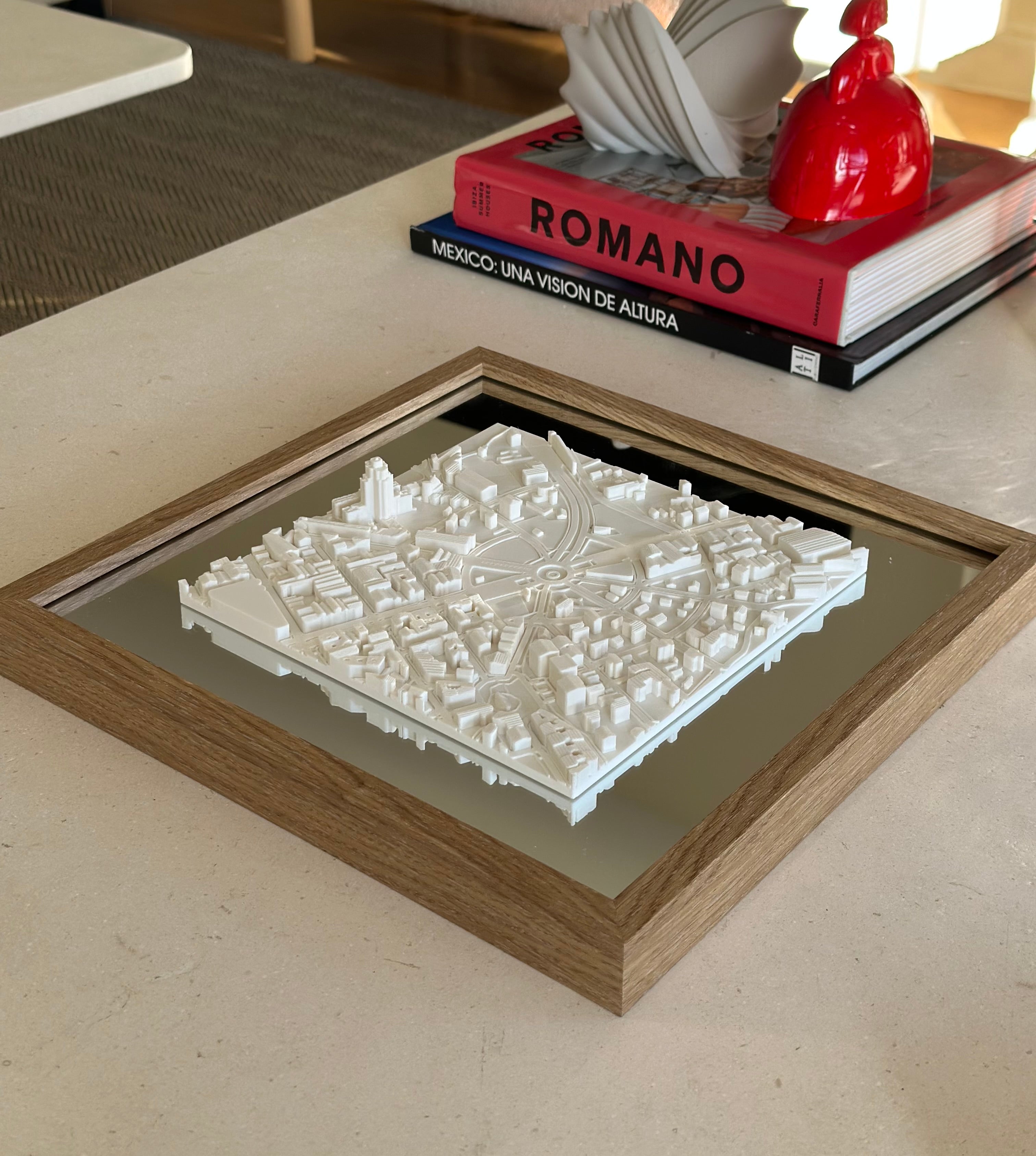 3D city map wall art in a wooden frame on a modern coffee table with books and decor.