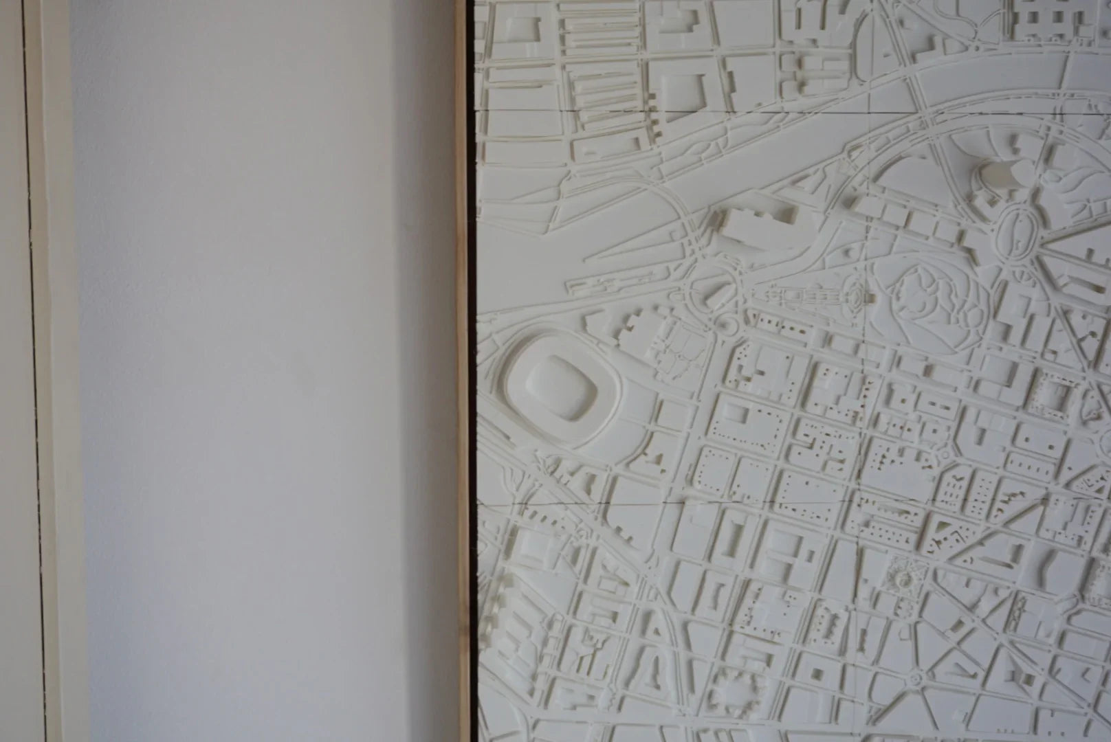Detail of a white 3D city map wall art featuring urban streets and landmarks