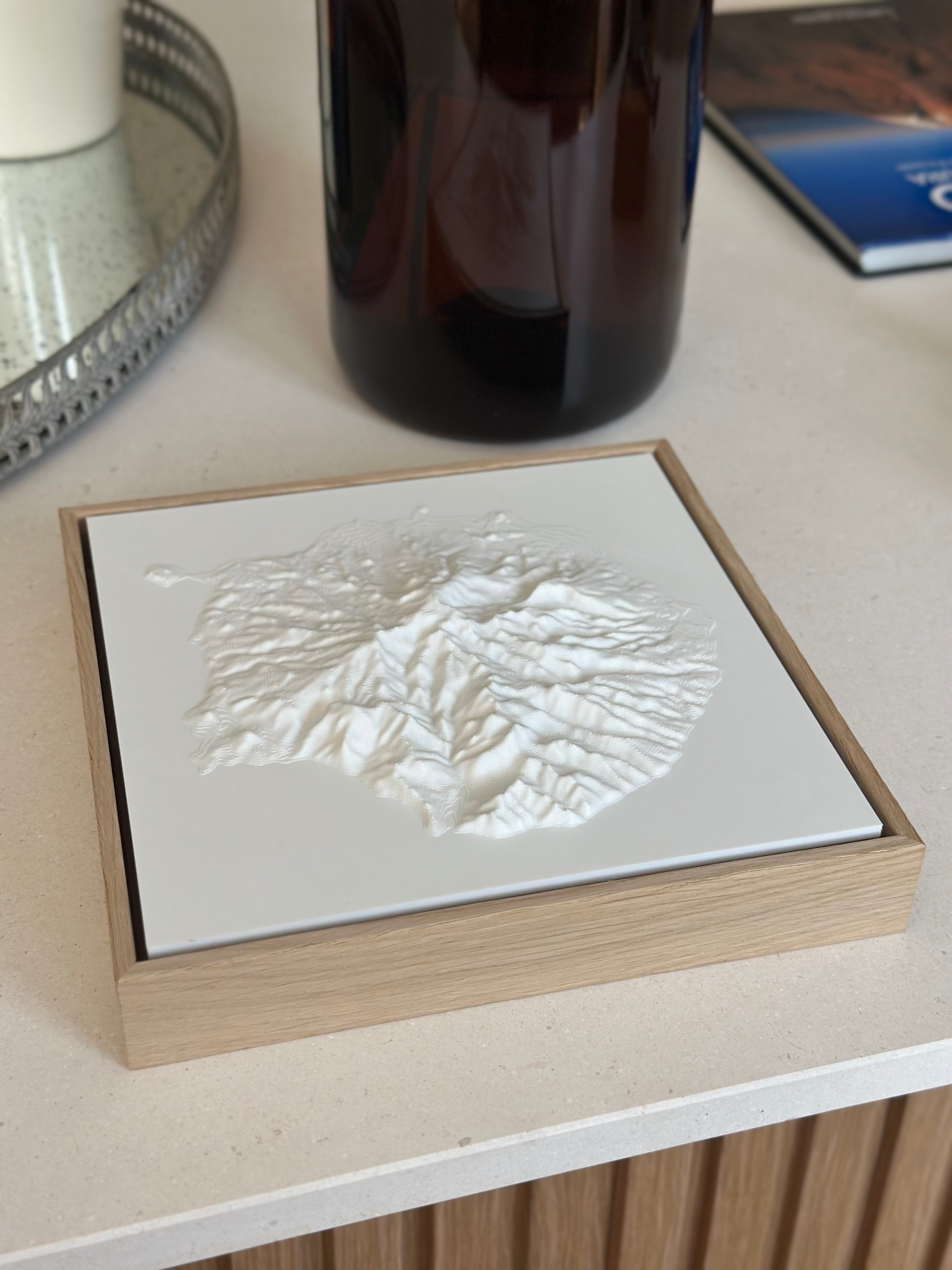 Framed 3D city map in white relief on a modern countertop, minimalist home decor