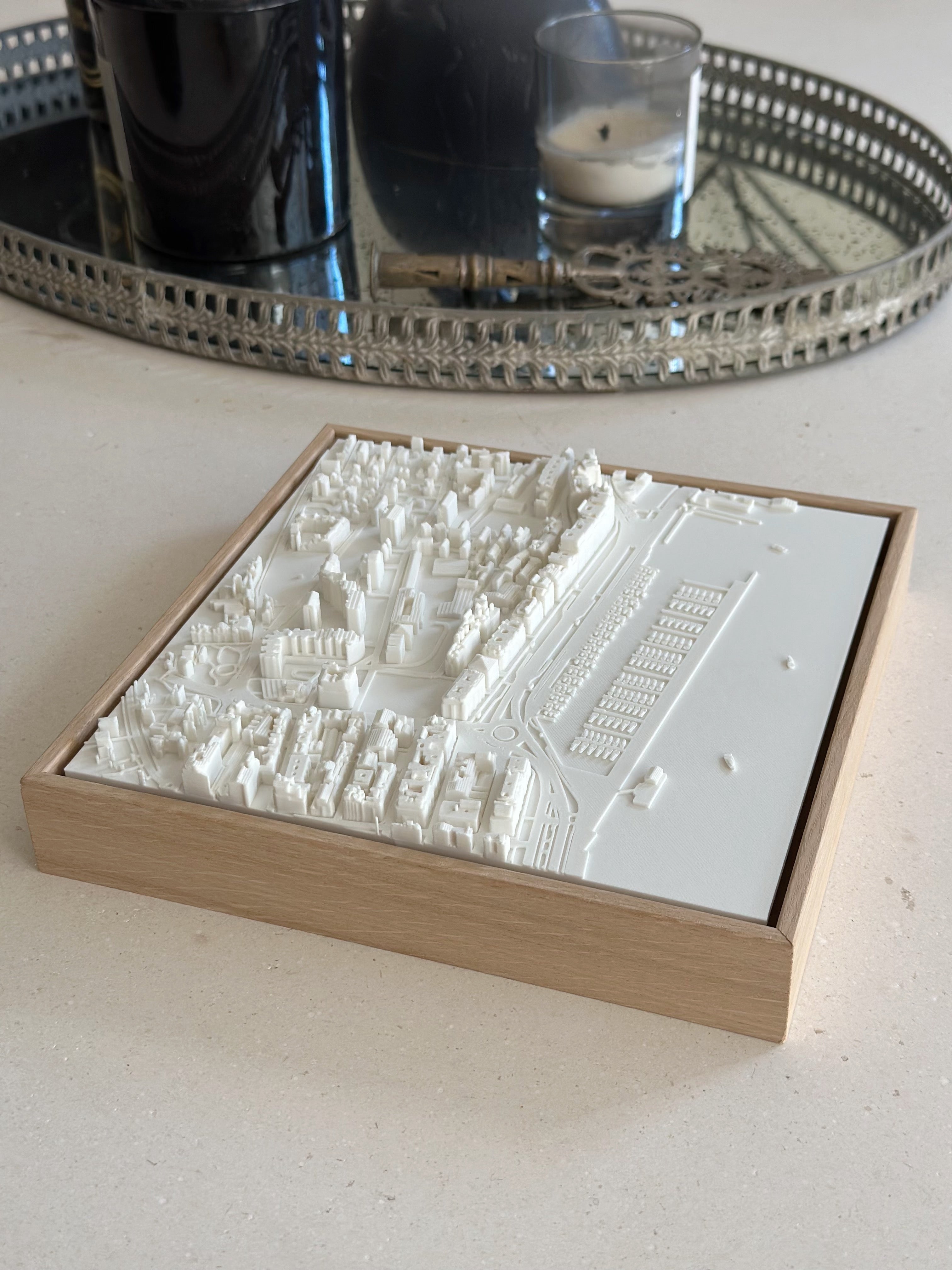 3D city map wall art in a wooden frame on a modern table with candles
