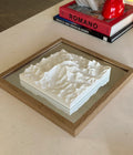 Framed 3D city map artwork with white topography on a table, modern decor style