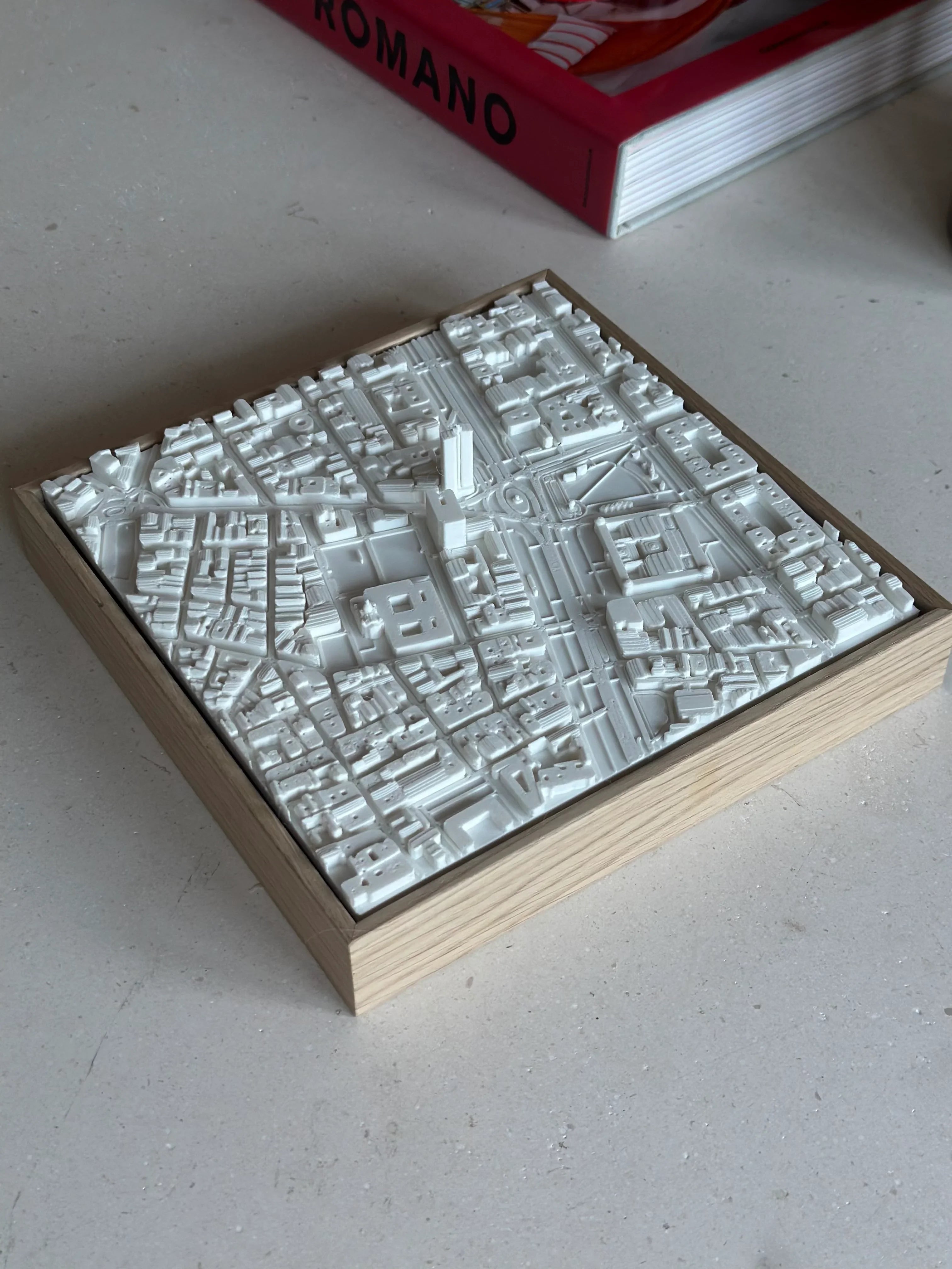 3D city map wall art in white with wood frame on a table, minimalist decor piece