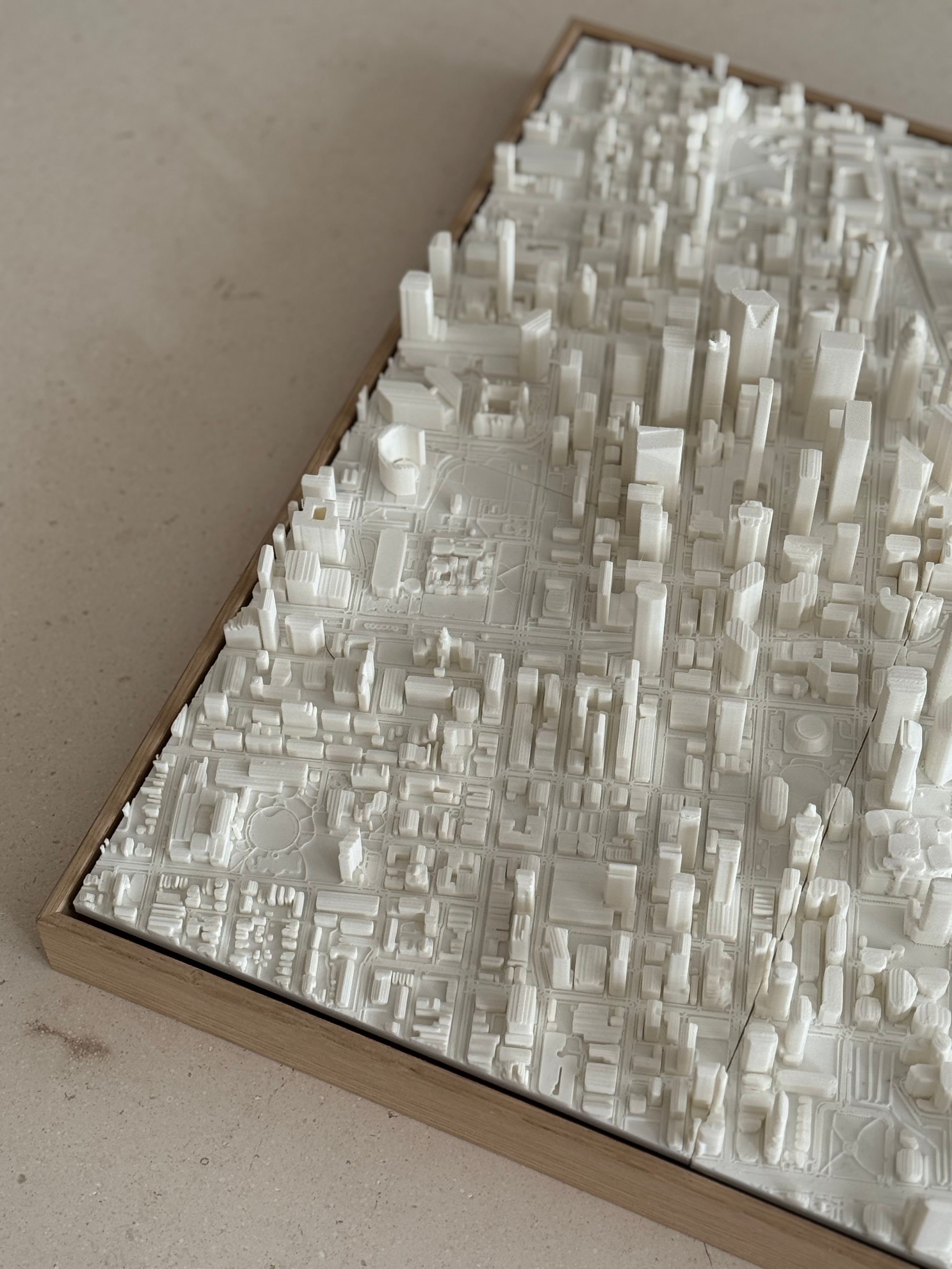 3D city map artwork with white buildings in a wooden frame, modern wall decor