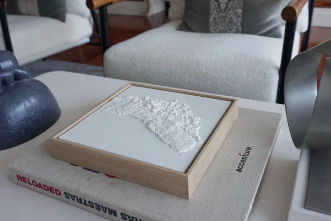 3D city map wall art with wooden frame on a modern living room table
