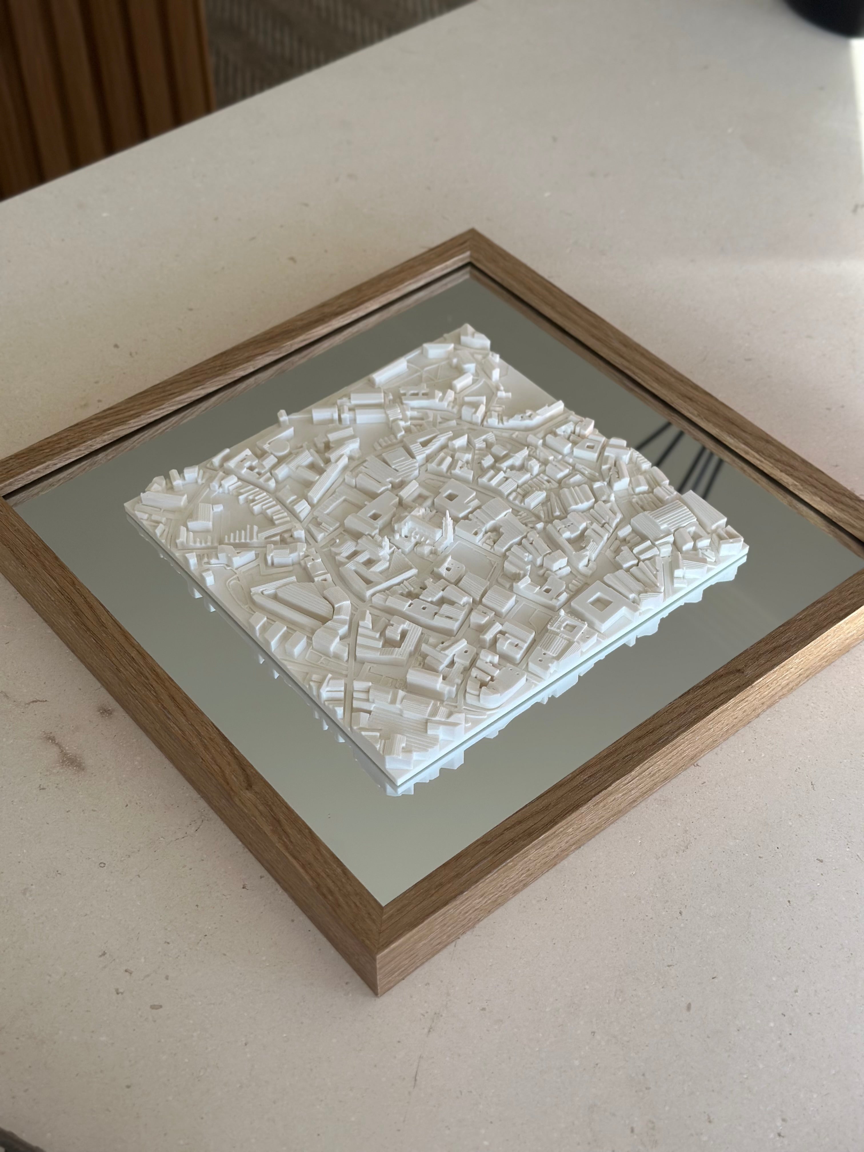 Framed 3D city map art in white on a mirrored surface, modern decorative wall decor