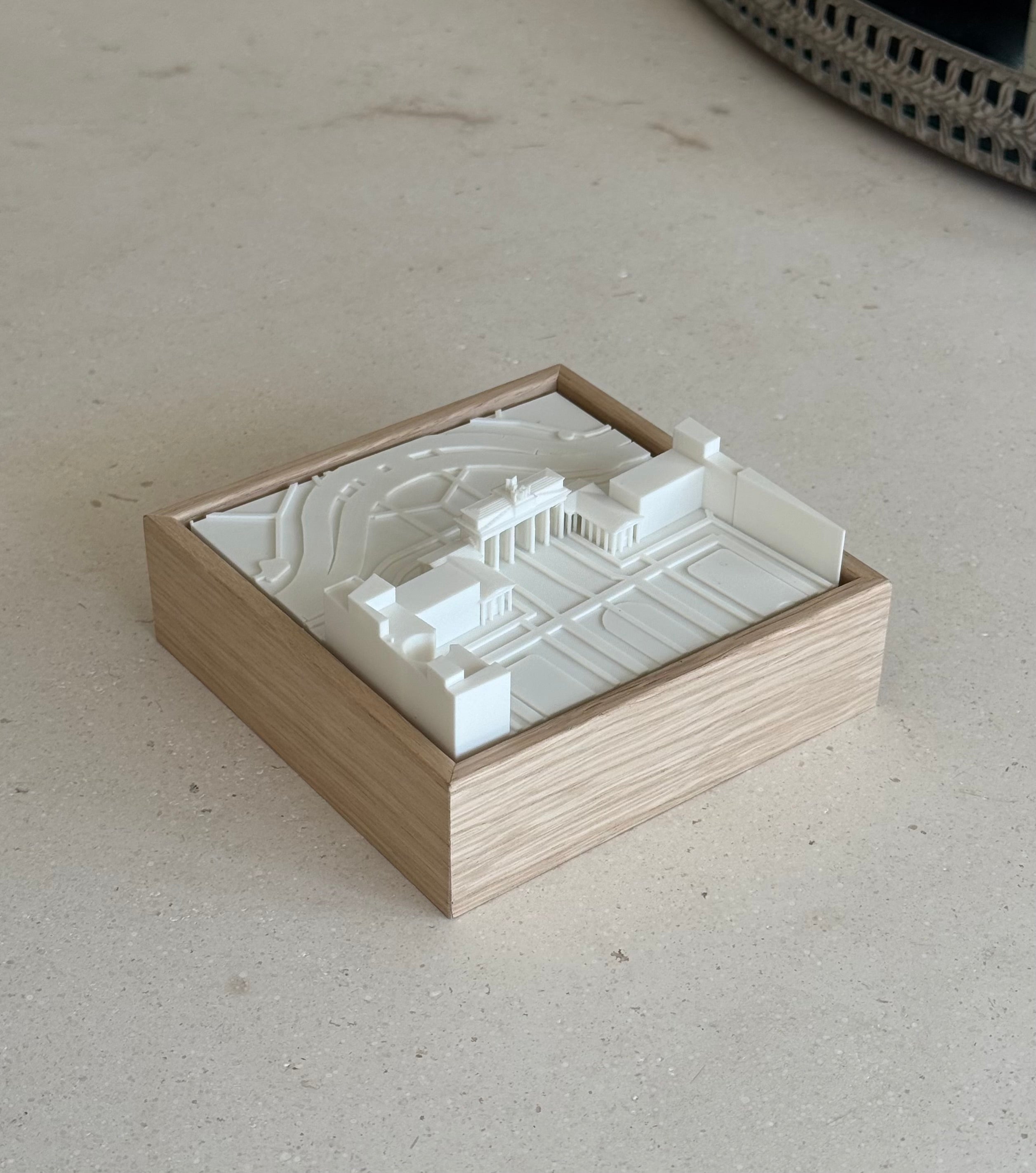 3D city map art in a wooden frame on a light stone surface, minimalist home decor