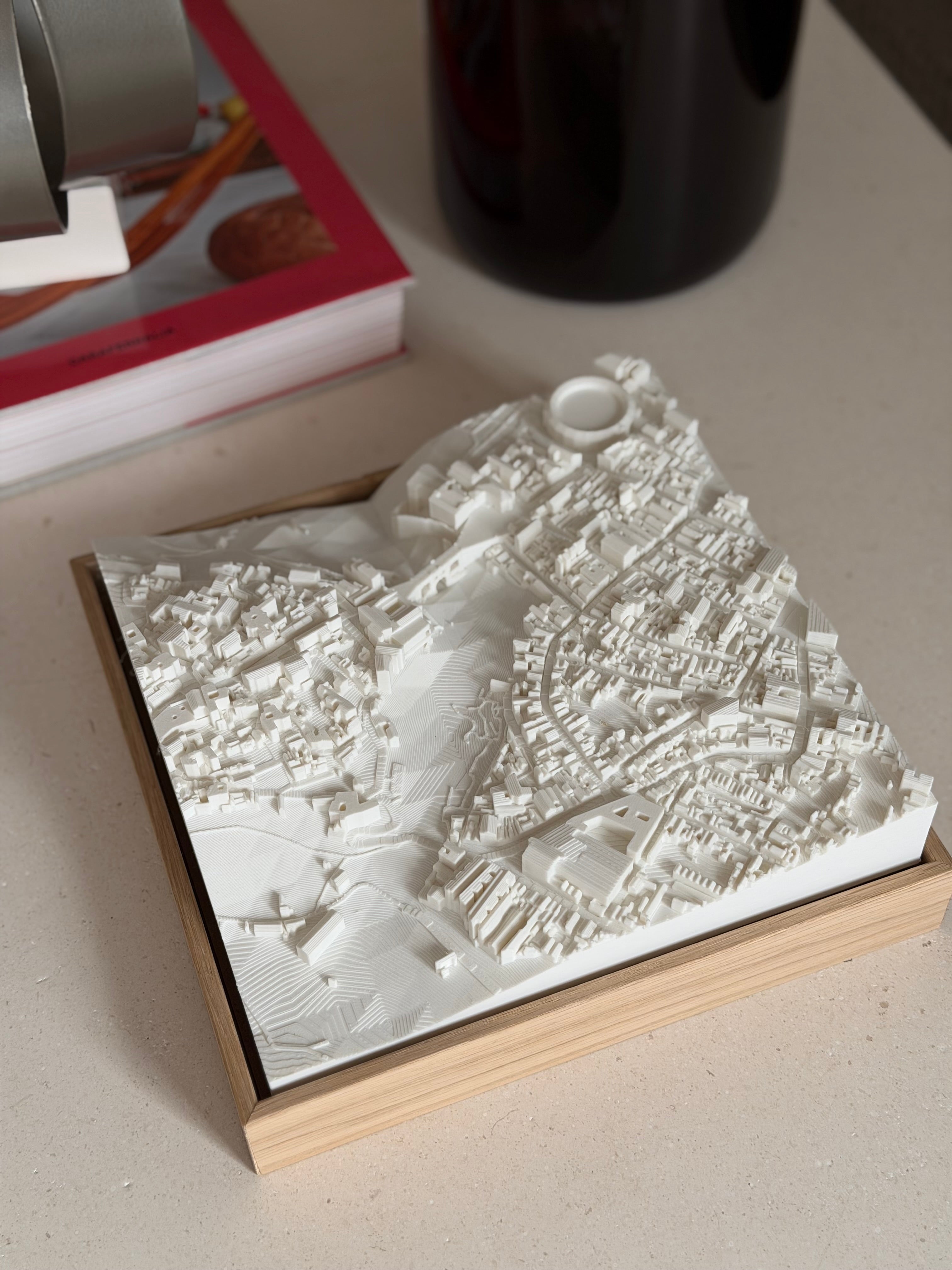 3D city map artwork in a wooden frame on a modern table, detailed urban decor