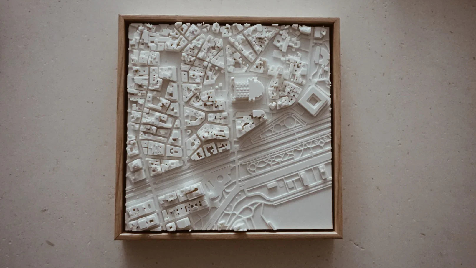 3D city map wall art with detailed white buildings in a wooden frame