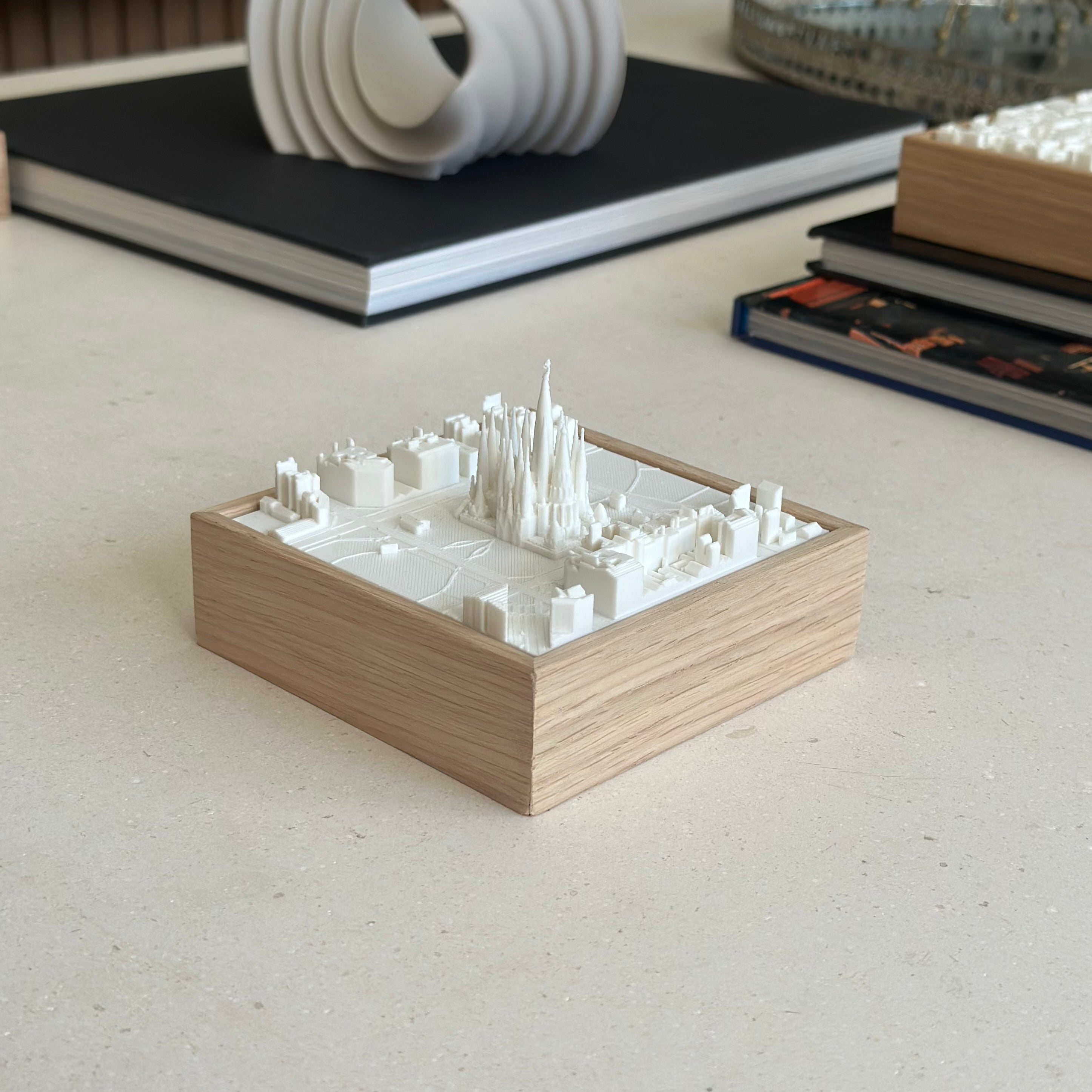 3D city map decorative art with wooden frame, featuring detailed white miniature buildings.