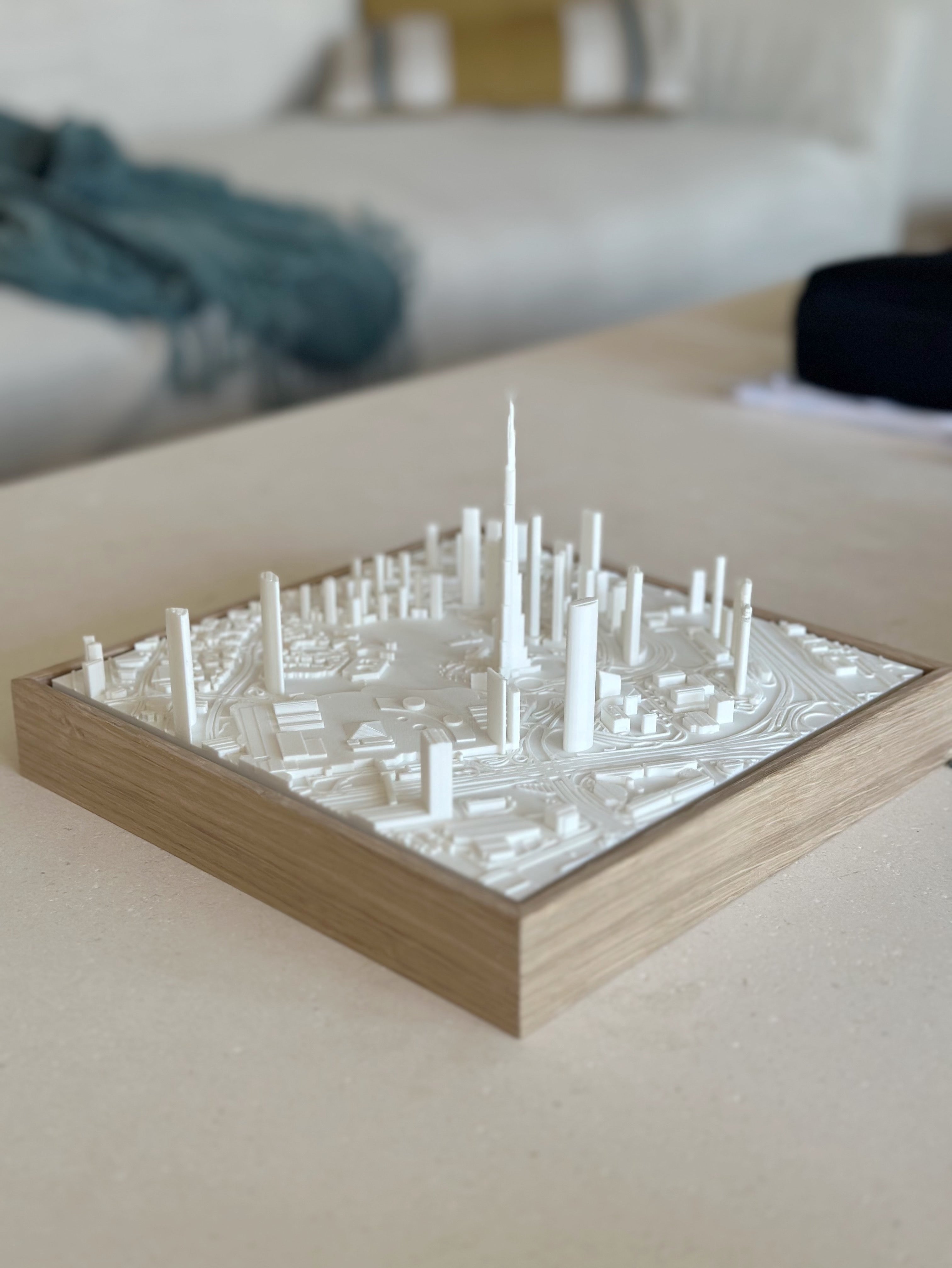 3D city map wall art in white with tall buildings on a wooden frame, modern decor piece