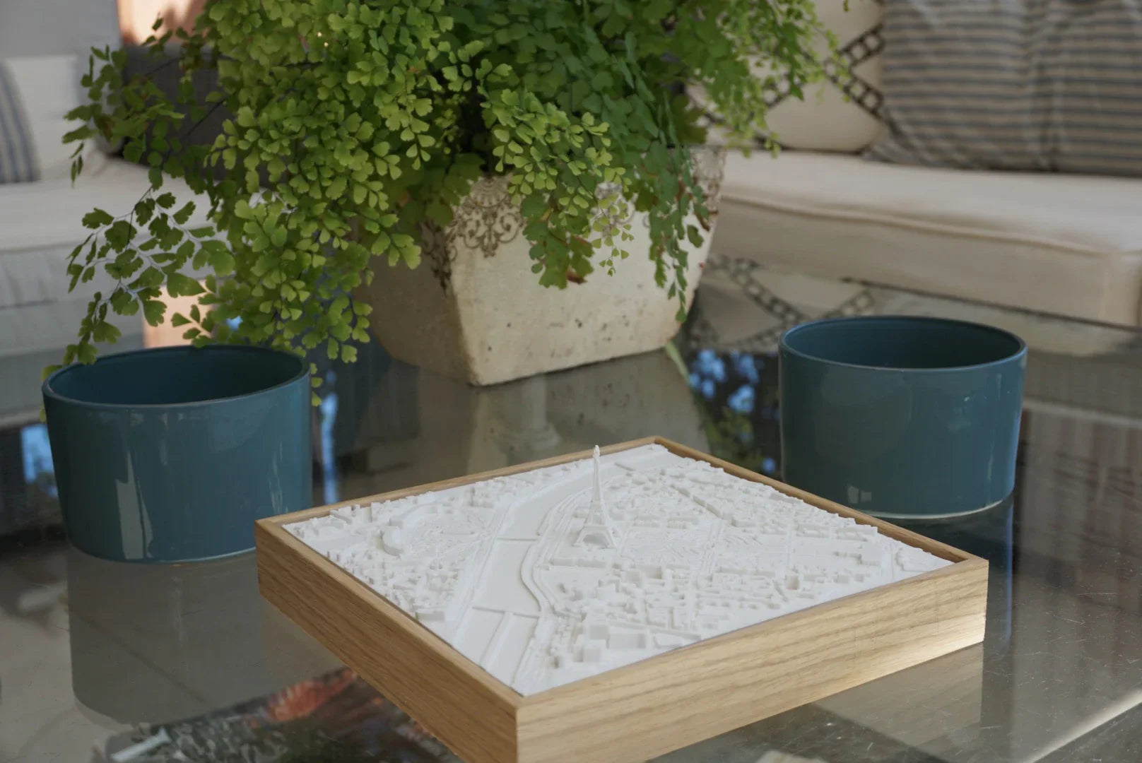 3D city map decor with wooden frame on glass table, greenery and modern home setting