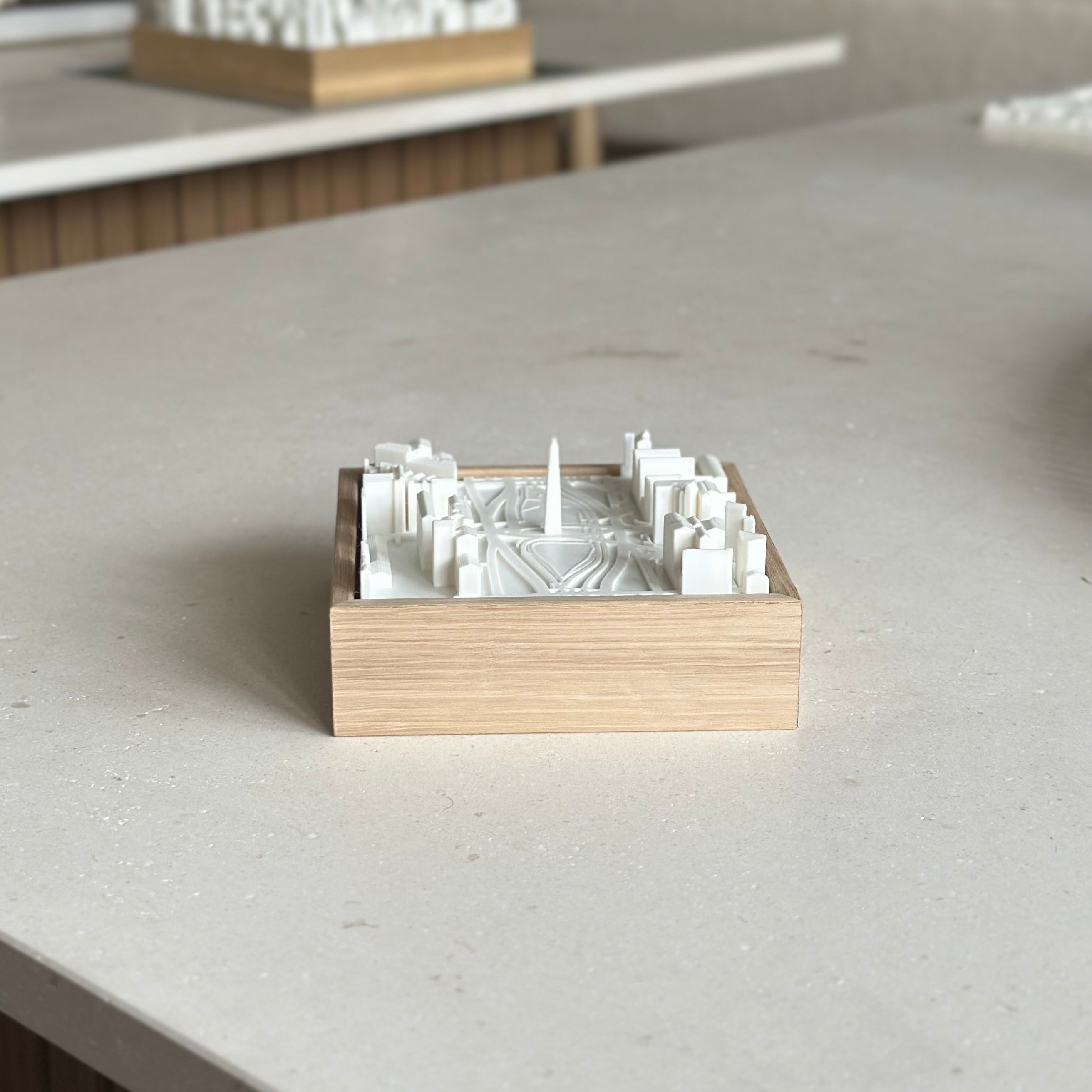 3D city map artwork in a wooden frame on a light table, modern decor piece