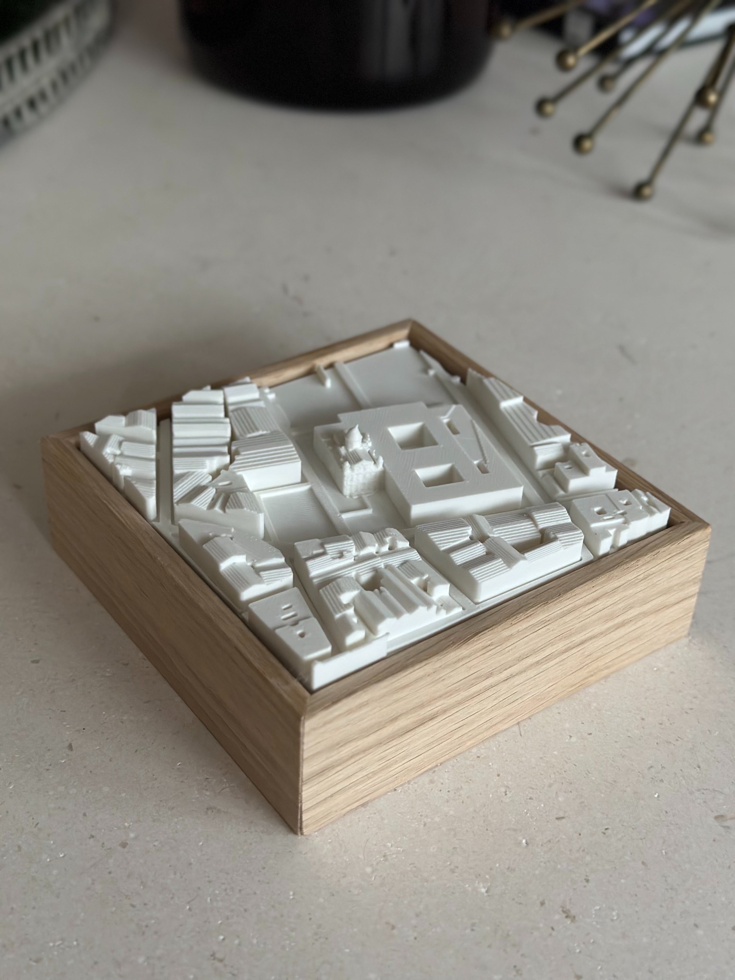 3D city map artwork in wooden frame, minimalist urban decor on a light surface