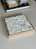Detailed 3D city map wall art in a wooden frame, modern home decor on a table
