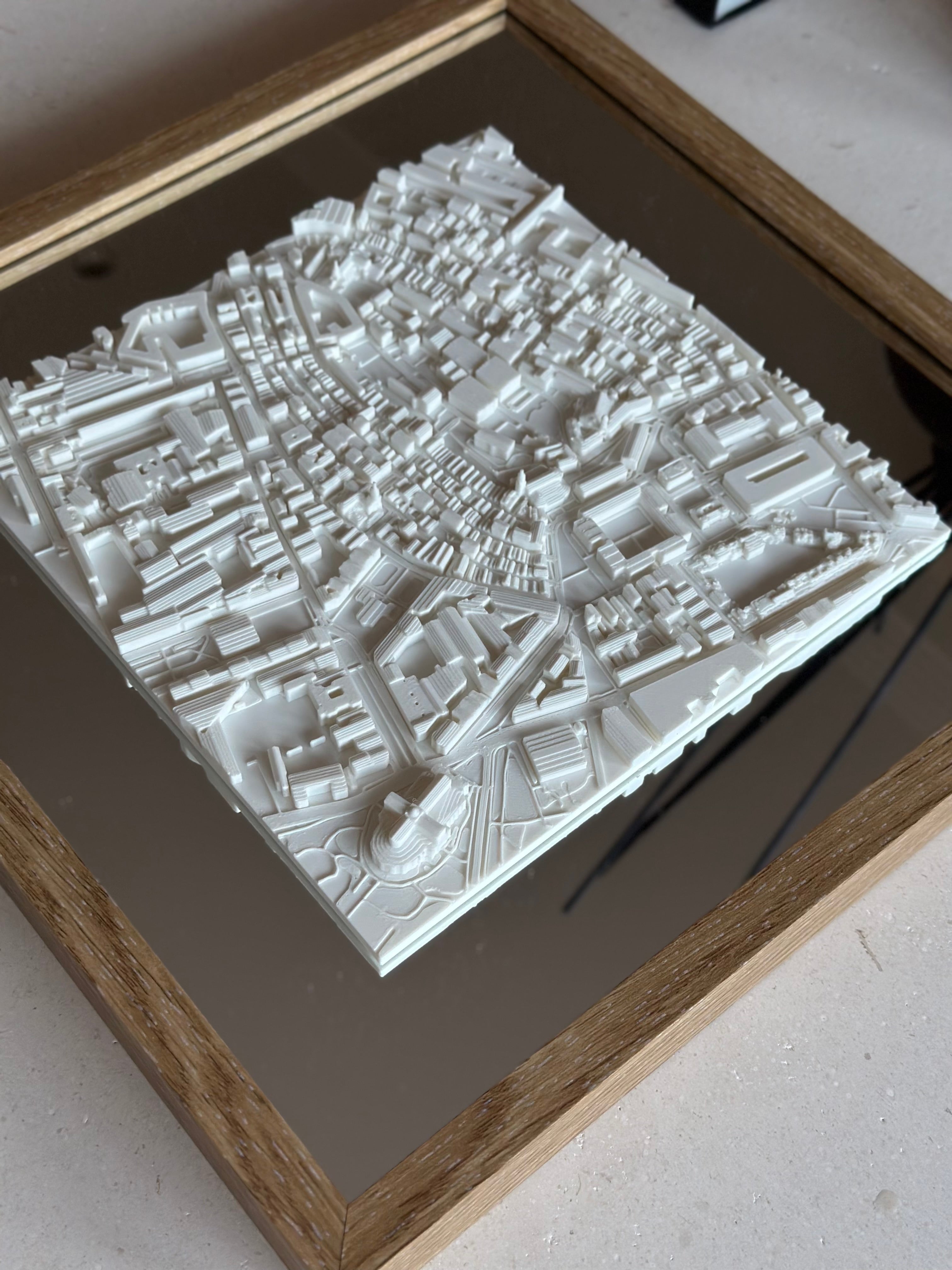 Framed 3D city map wall art with detailed white buildings on a mirror background