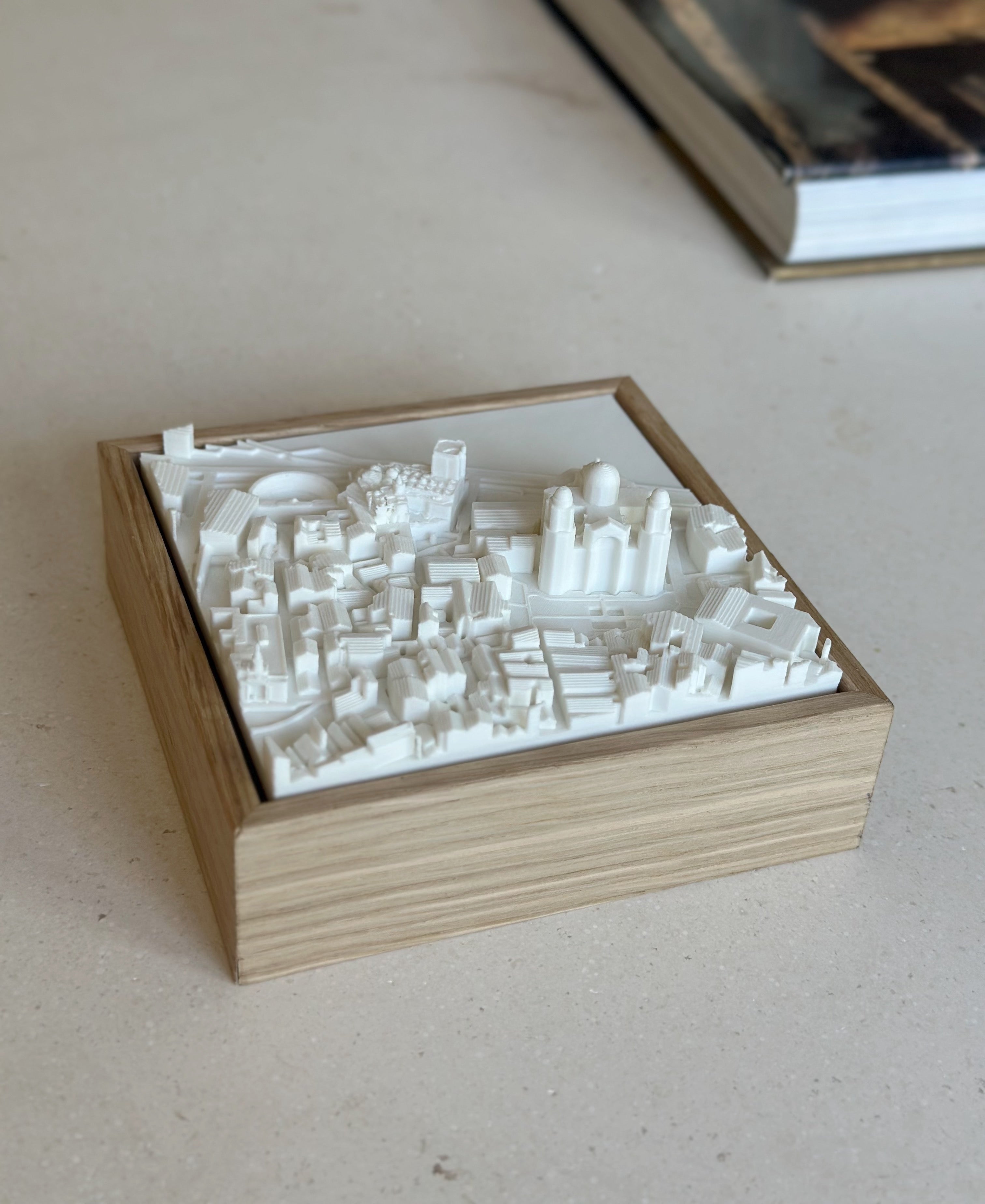 3D city map artwork in a wooden frame, modern cityscape decor piece on a table