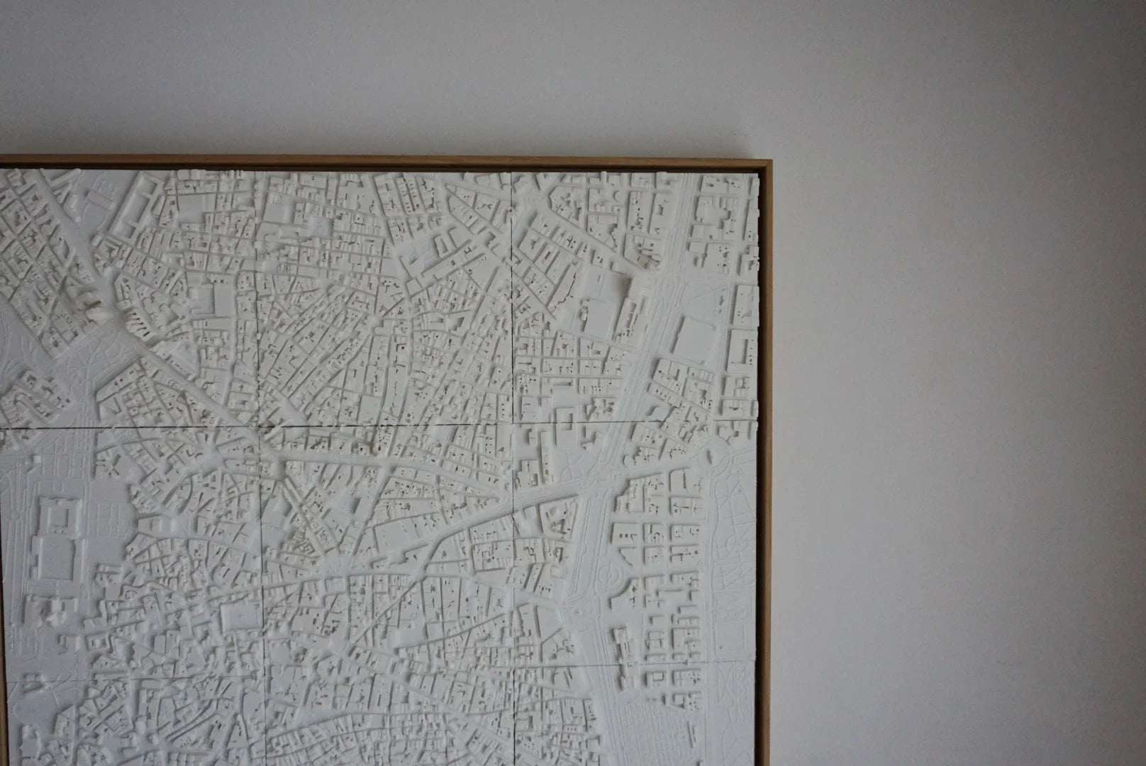 Framed 3D city map wall art in white, showing detailed urban streets and buildings