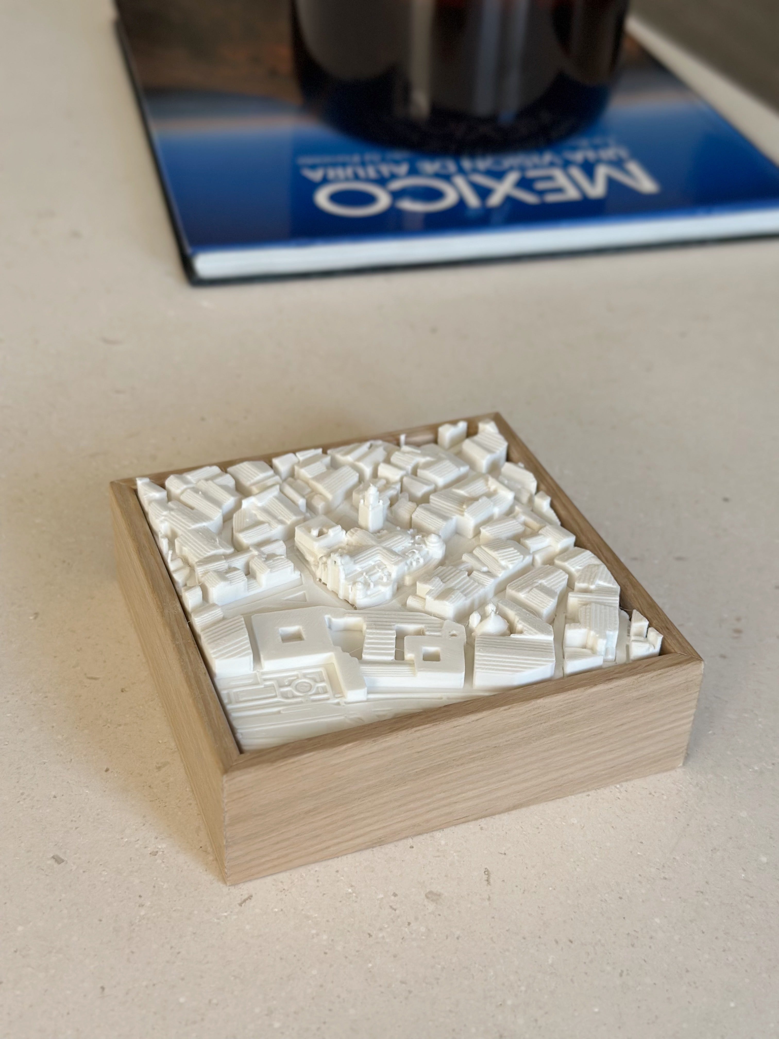 3D city map art in wooden frame on a table, modern cityscape decorative piece