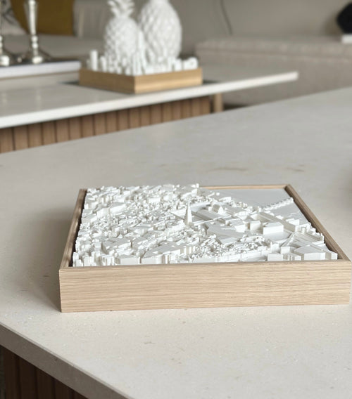 3D city map wall art in a wooden frame on a modern coffee table, minimalist decor