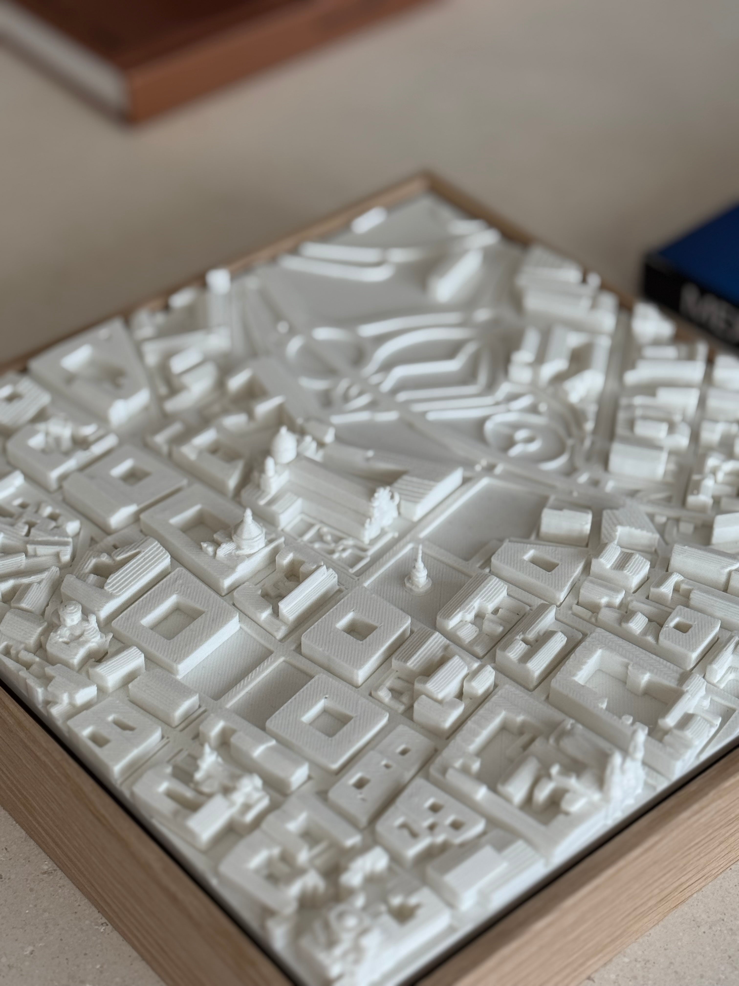 3D city map art piece with detailed white buildings on a wooden base, modern home decor