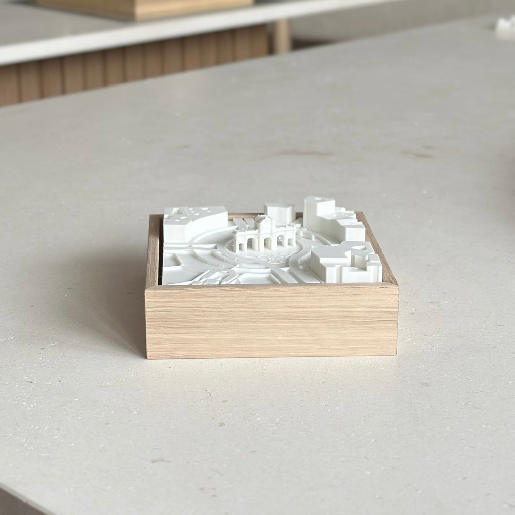 3D city map wall art in a wooden frame on a light tabletop, minimalist home decor