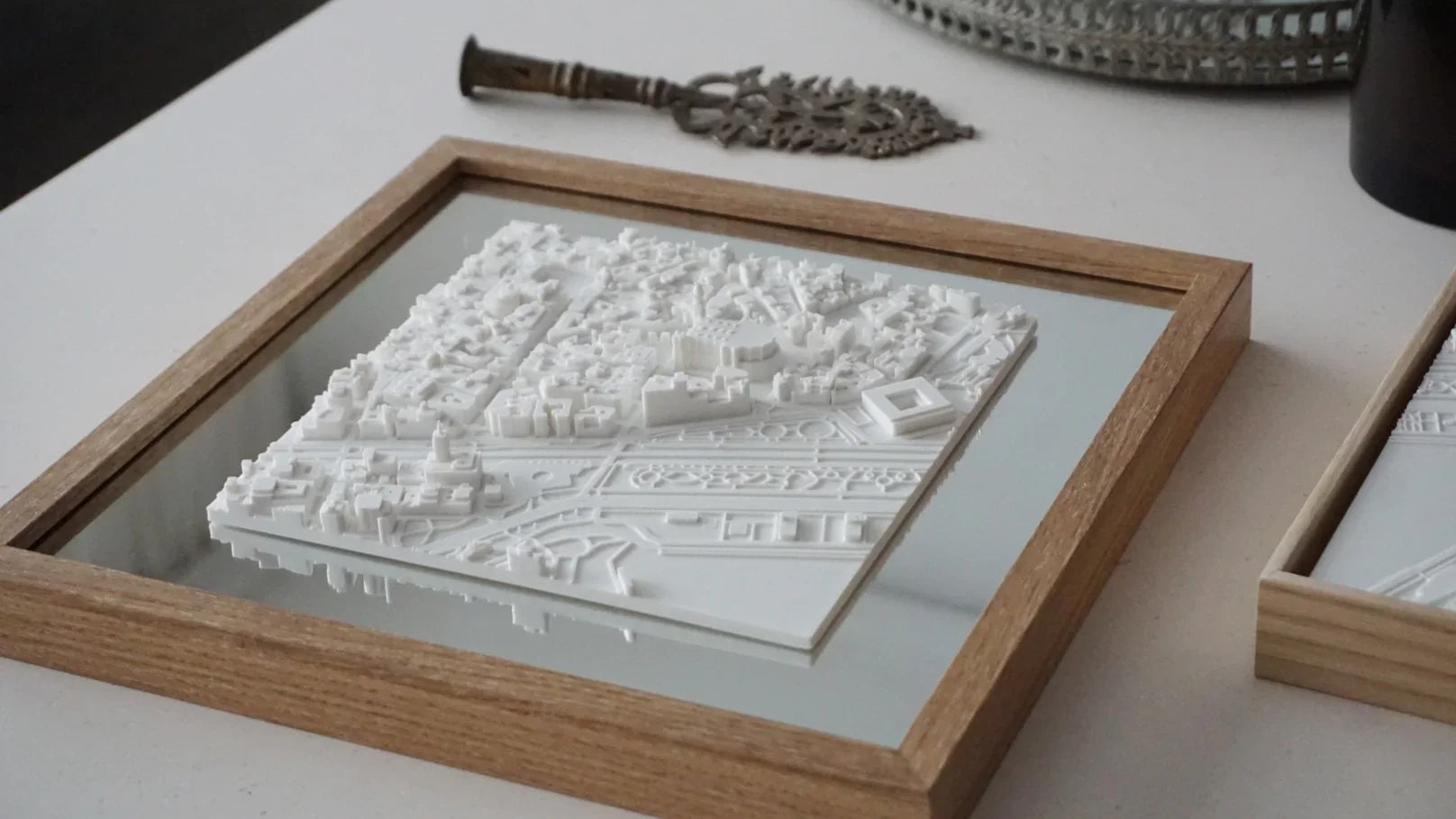 3D city map wall art in a wooden frame on a white table, modern home decor