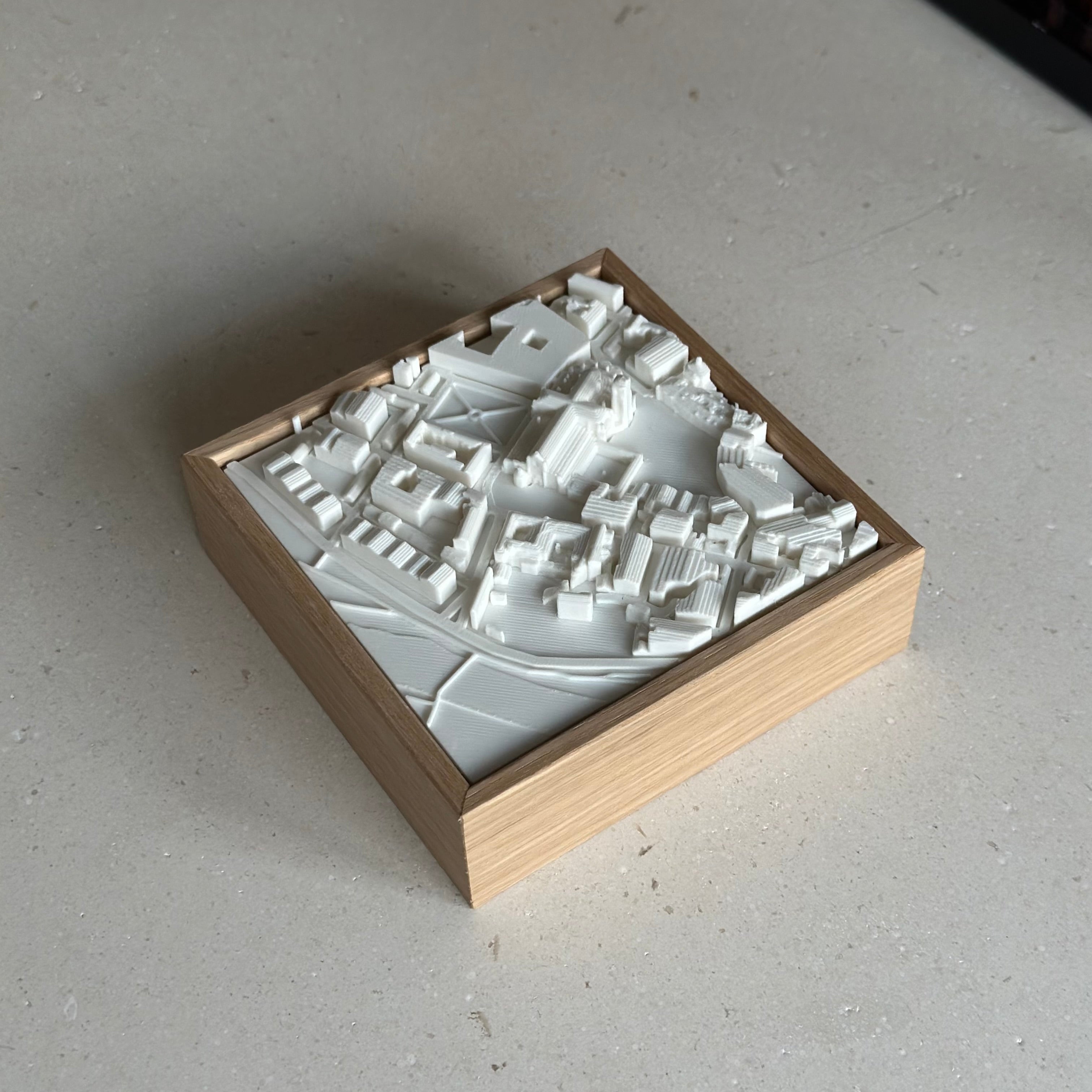 3D city map artwork in a wooden frame, modern decorative piece on a light surface