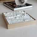 3D city map wall art in a wooden frame on a modern table, with a book in the background