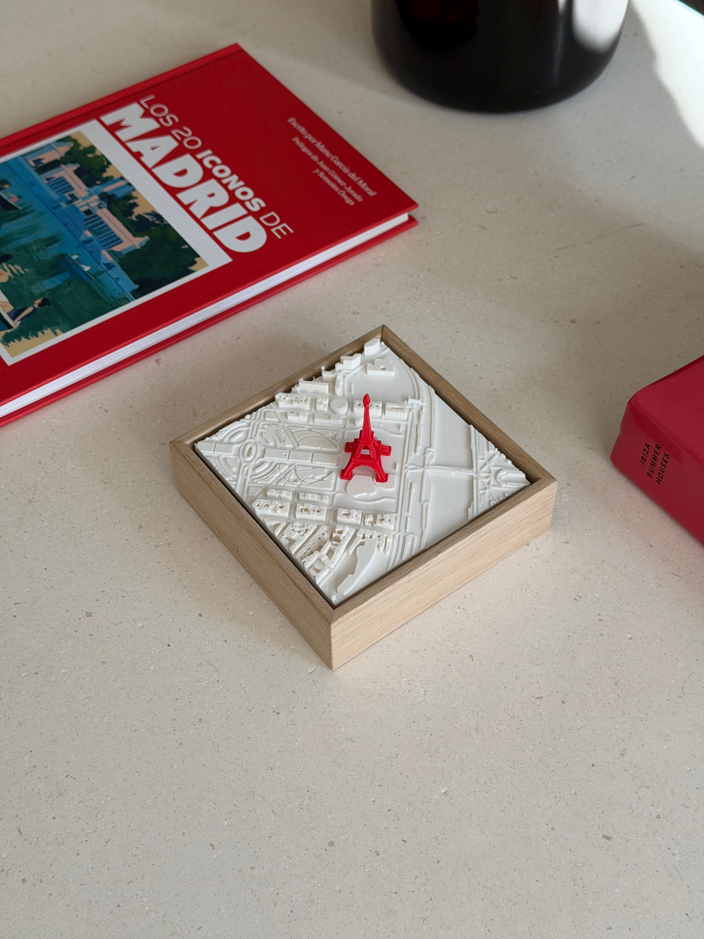 3D city map art of Paris with red Eiffel Tower in wooden frame on a table