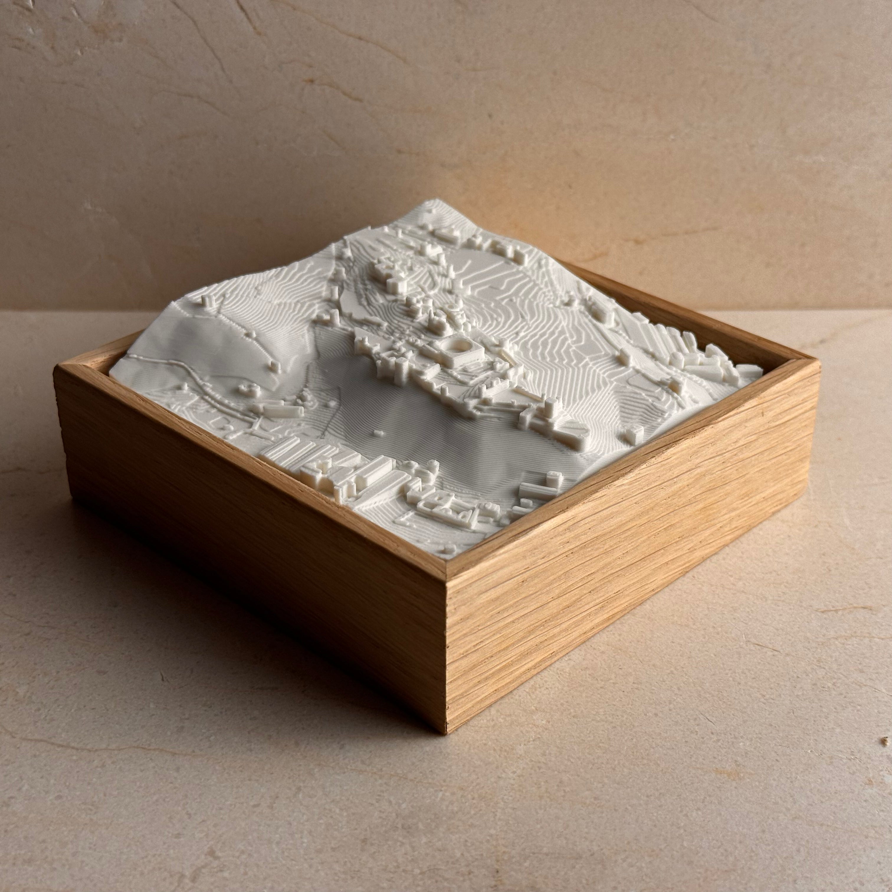 3D map of Granada in white, displayed in a wooden frame as decorative wall art.