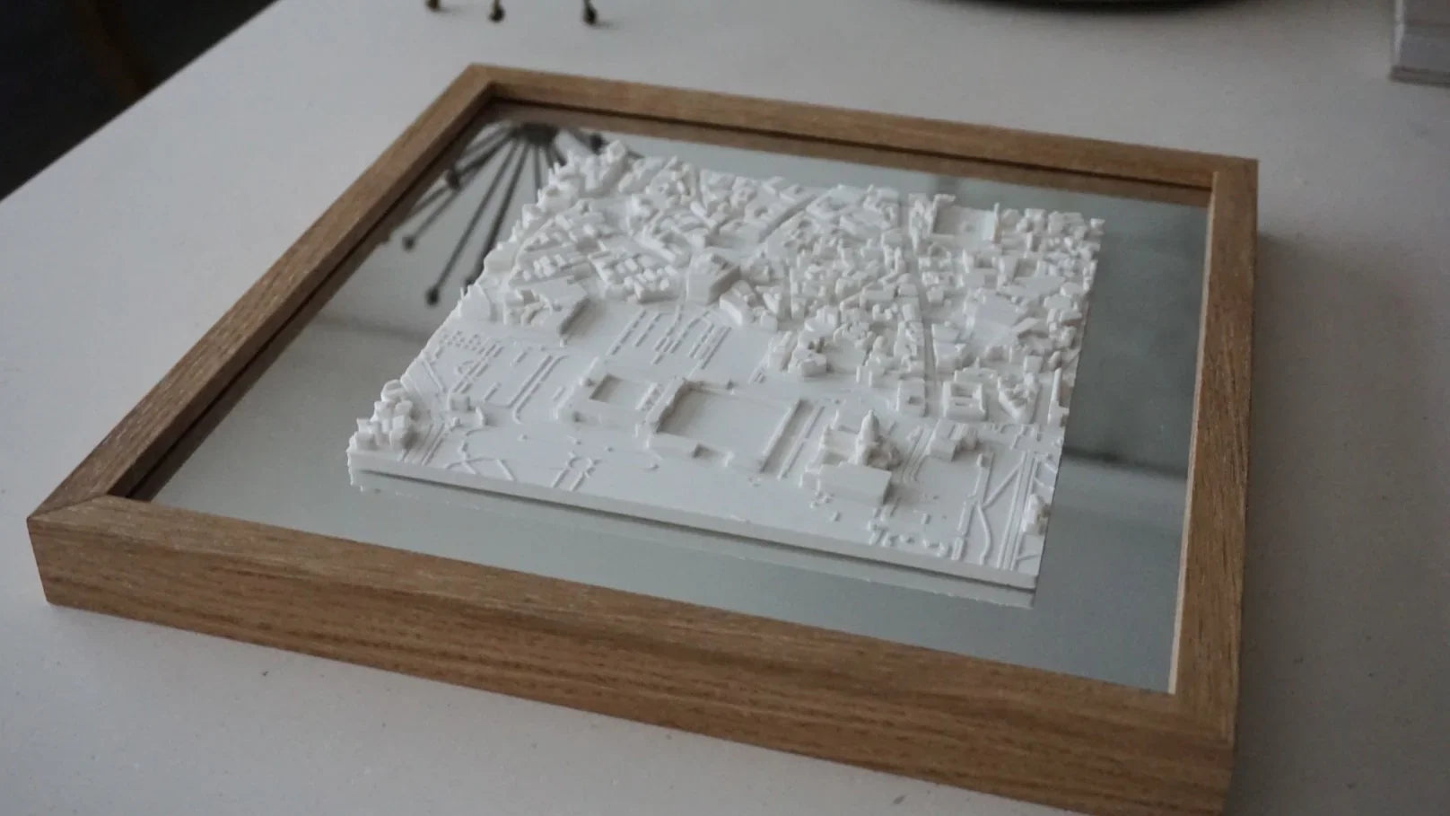 3D city map wall art in a wooden frame on a table, modern home decor detail