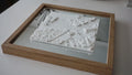 Framed 3D city map wall art with detailed white topographic buildings on a reflective base