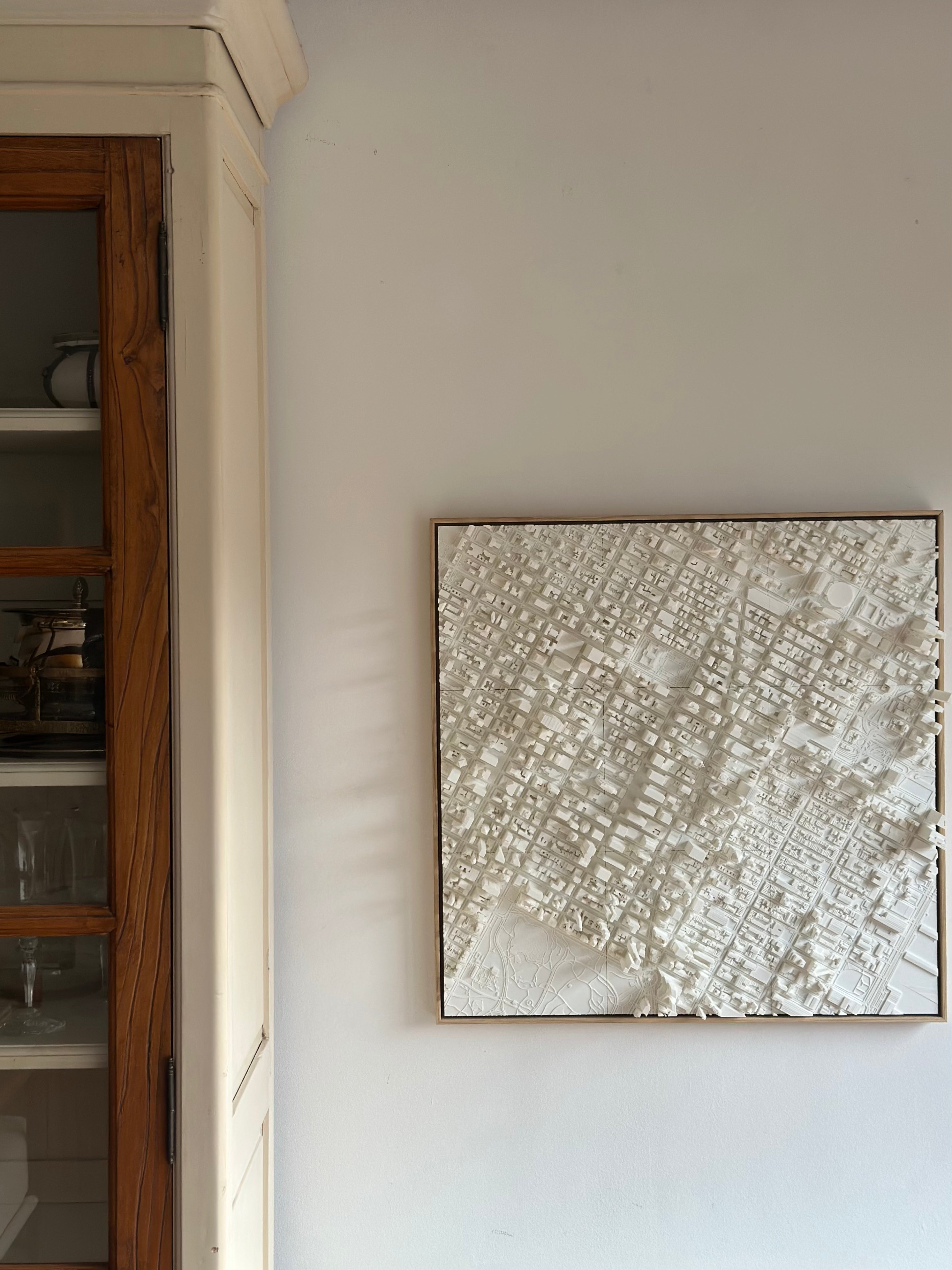 Modern living space with a framed 3D city map wall art in white, urban home decor