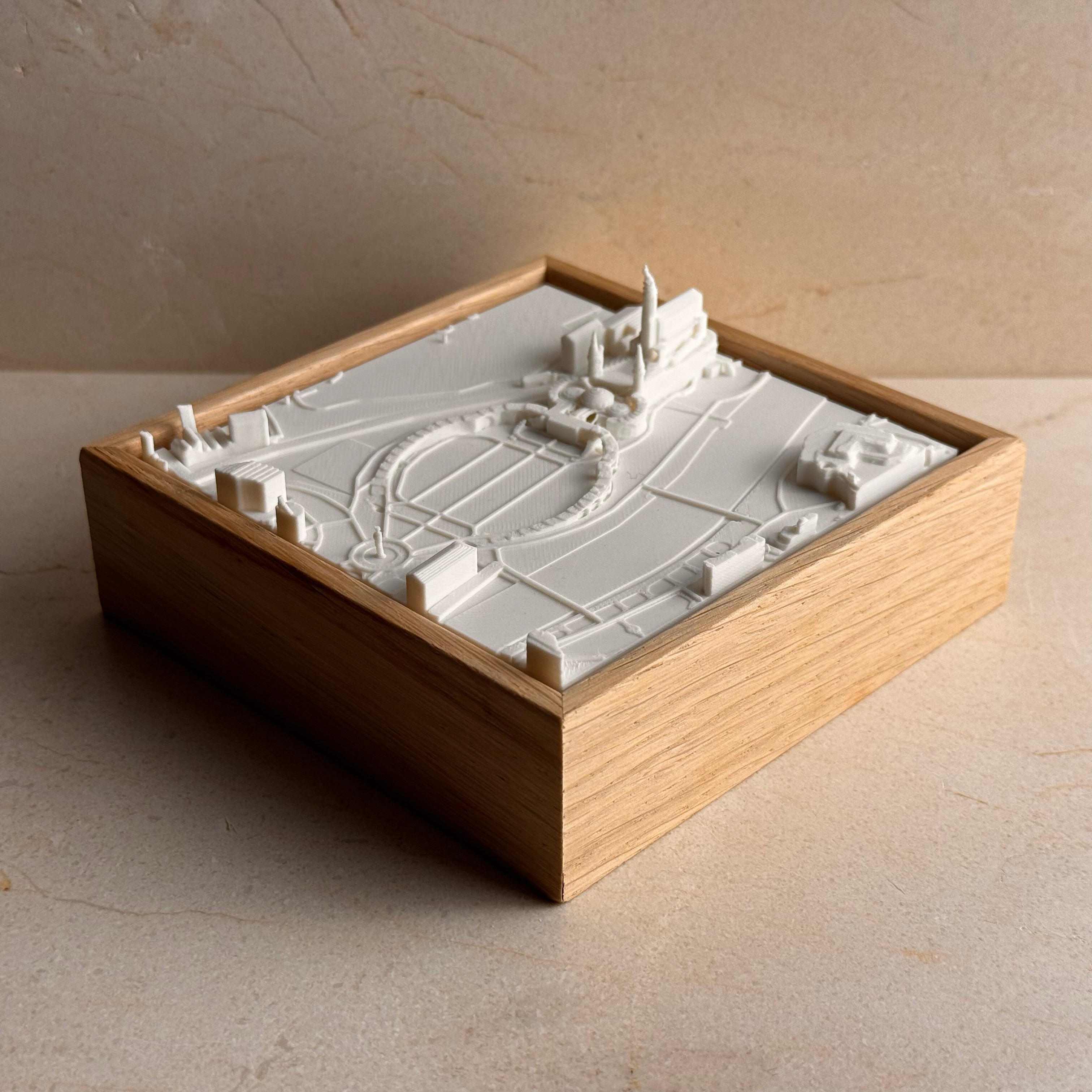 3D map art miniature of a city with architectural landmarks in a wooden frame display